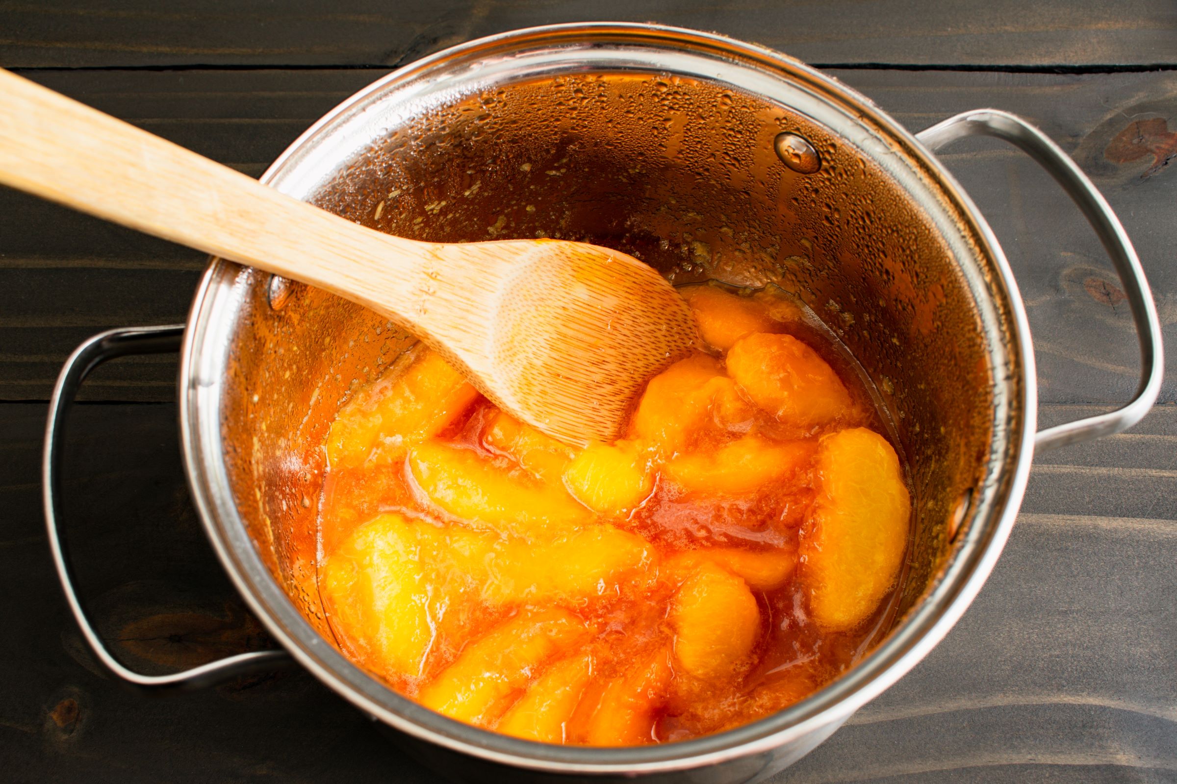 Sliced peaches simmering in a pot