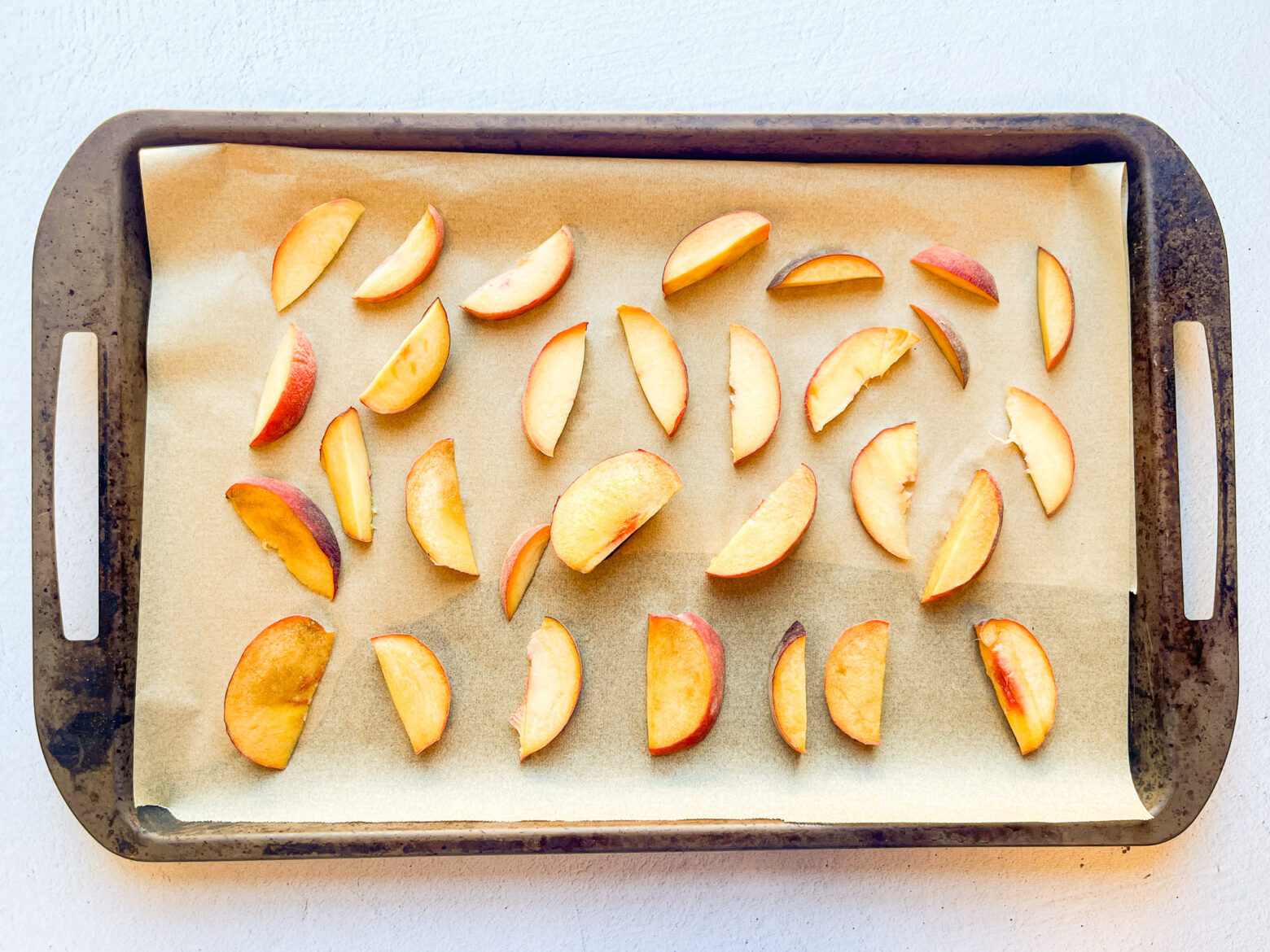 Iced green peach tea peach sliced on a baking sheet.