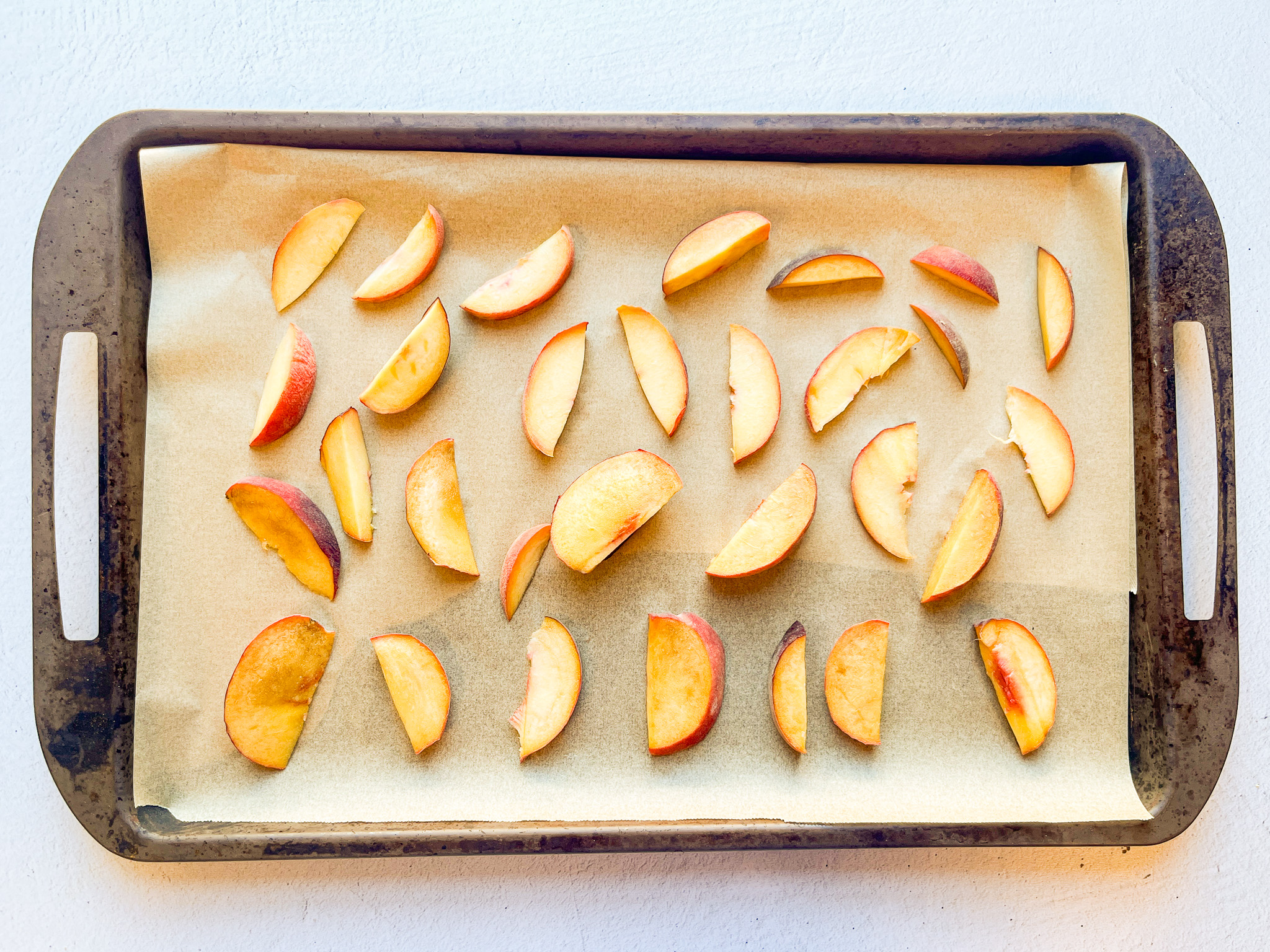 Iced green peach tea peach sliced on a baking sheet. 