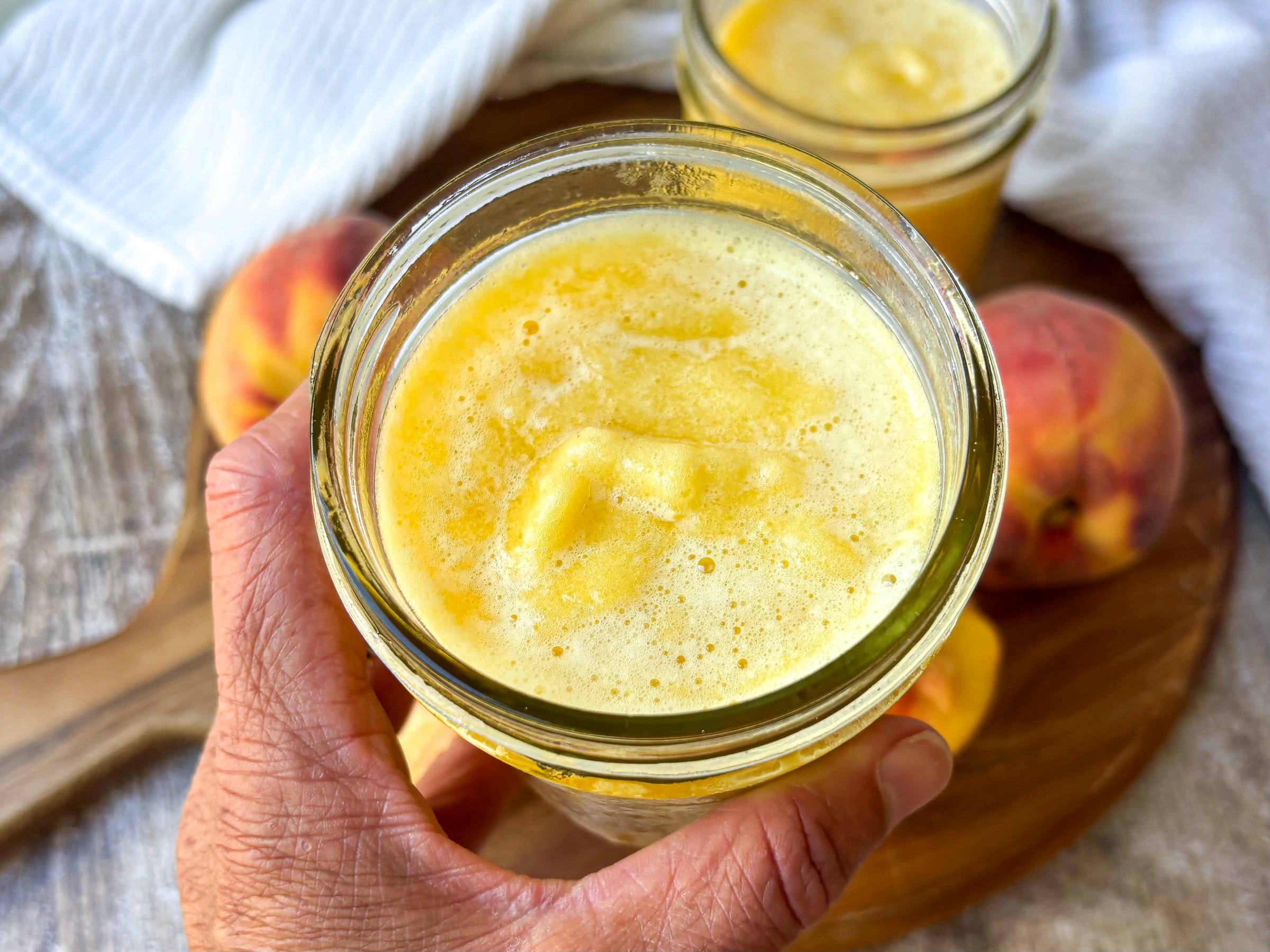 Hand holding Frozen Peach Green Tea
