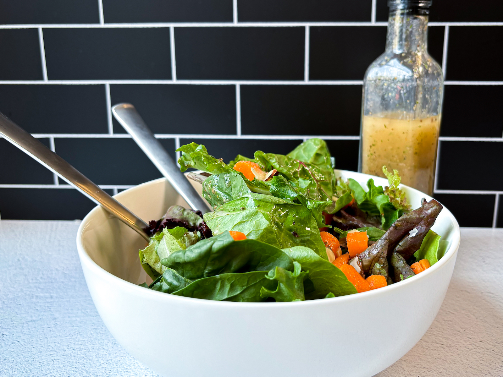 Final photo of Italian Dressing on salad with a bottle of the dressing in the background