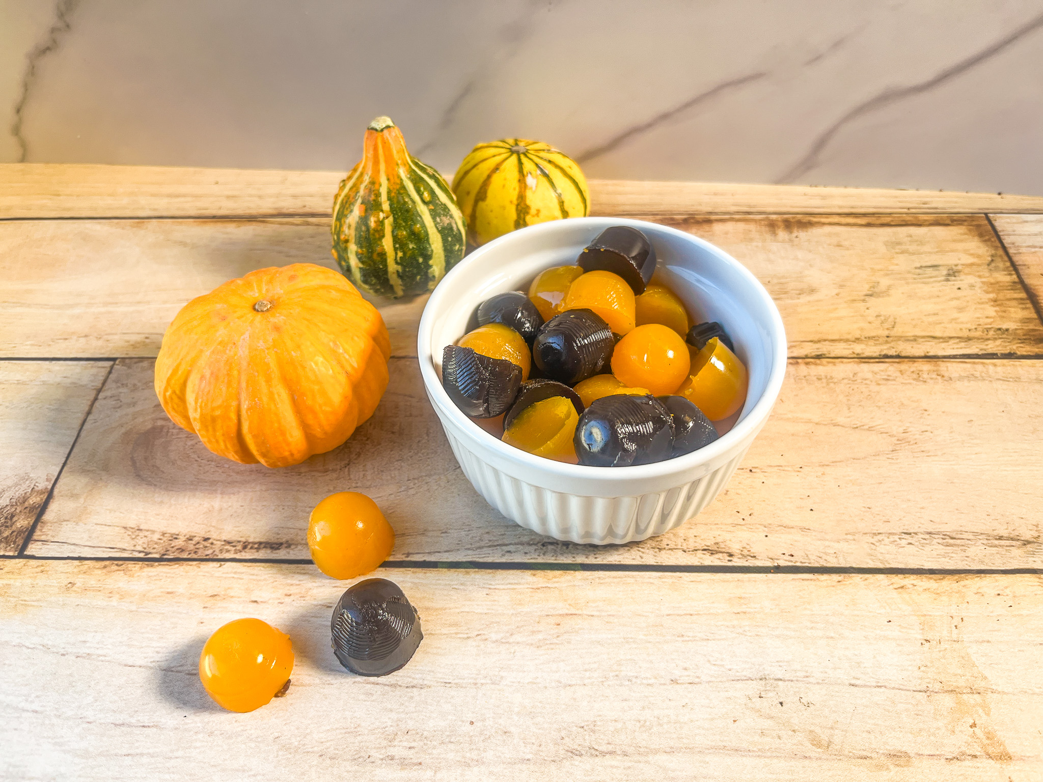 Halloween gummies in a bowl with pumpkins.