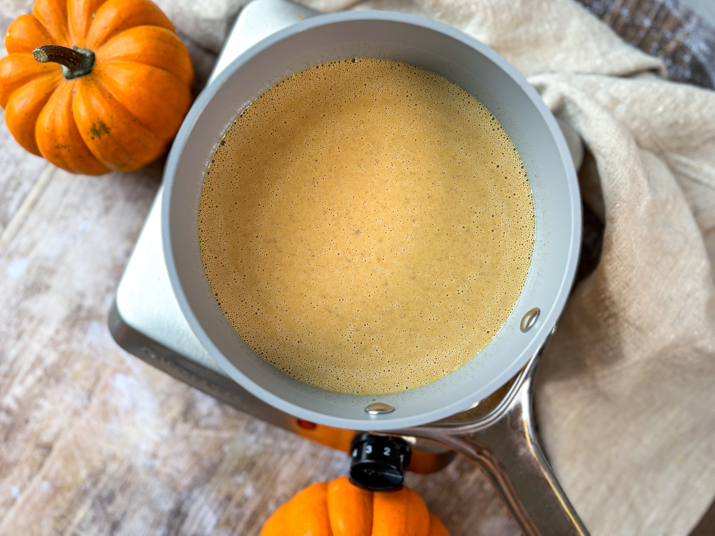 Pumpkin coffee creamer over the stove in a oan cooking. 