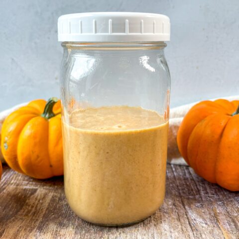 Pumpkin coffee creamer in a mason jar with pumpkins.