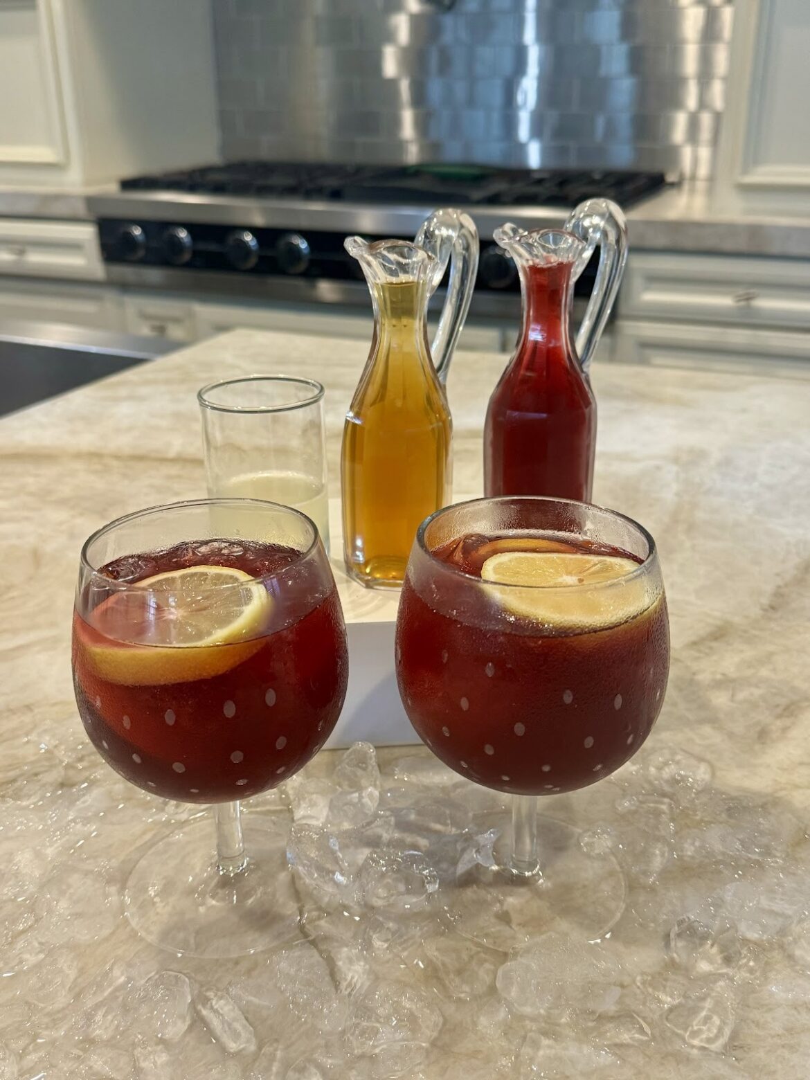 Two glasses of citrus and bitters mocktail on a kitchen counter