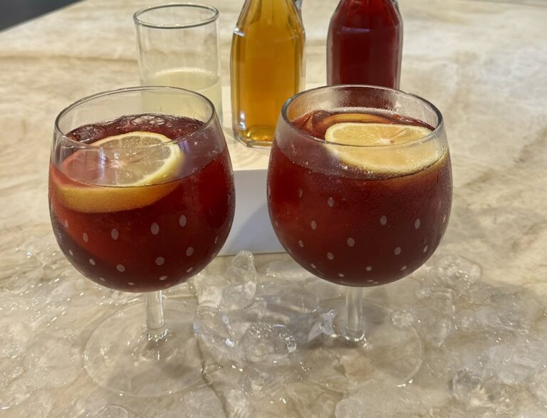 Two glasses of citrus and bitters mocktail on a kitchen counter