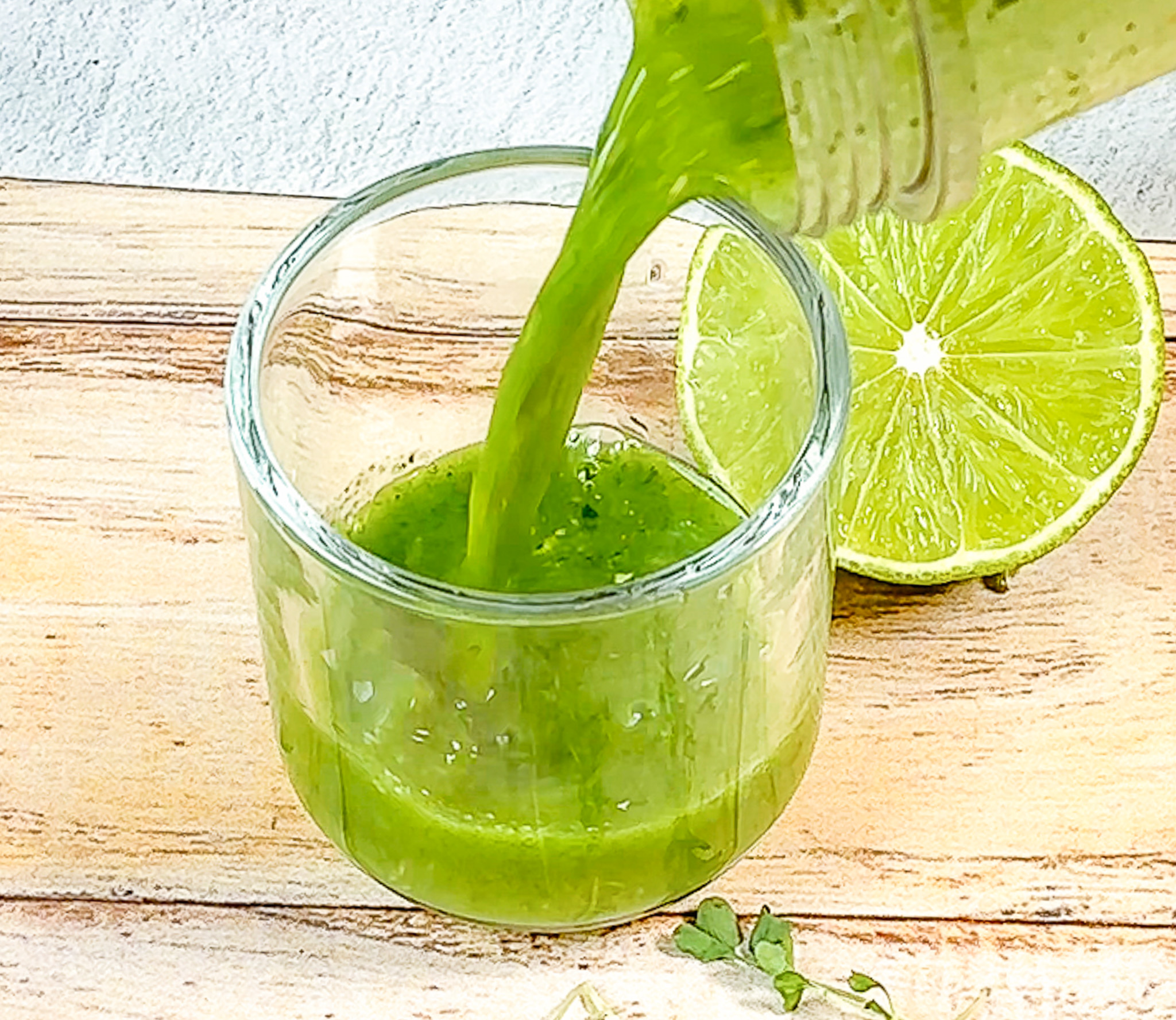 Broccoli Microgreens Wellness Shots being poured into a shot glass. 