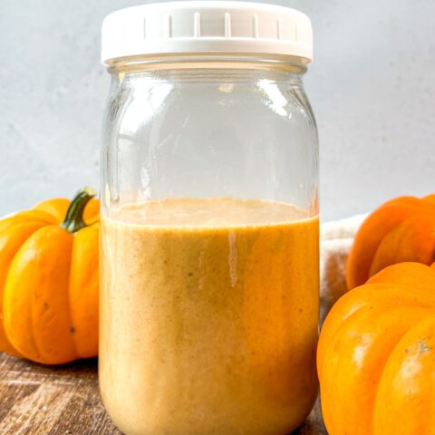 Pumpkin coffee creamer in a mason jar with pumpkins.