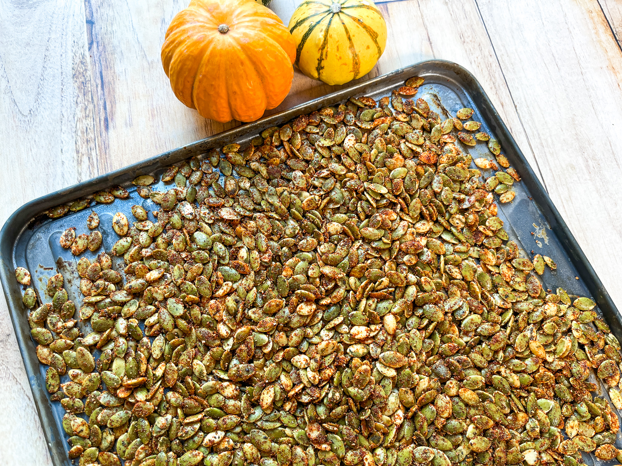 Spiced pumpkin seeds prepped on a baking sheet. 