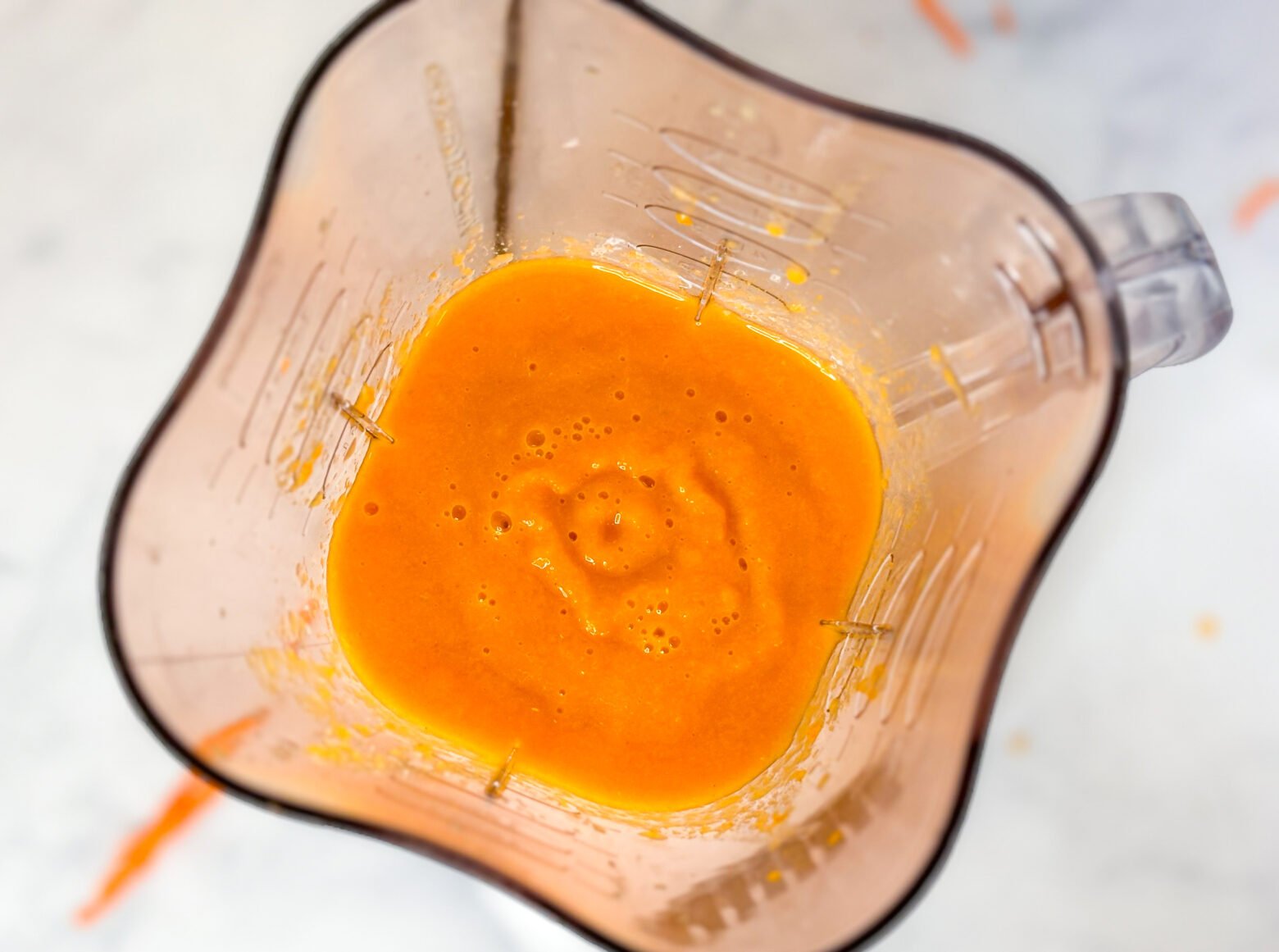 Carrot smoothie blended in blender.