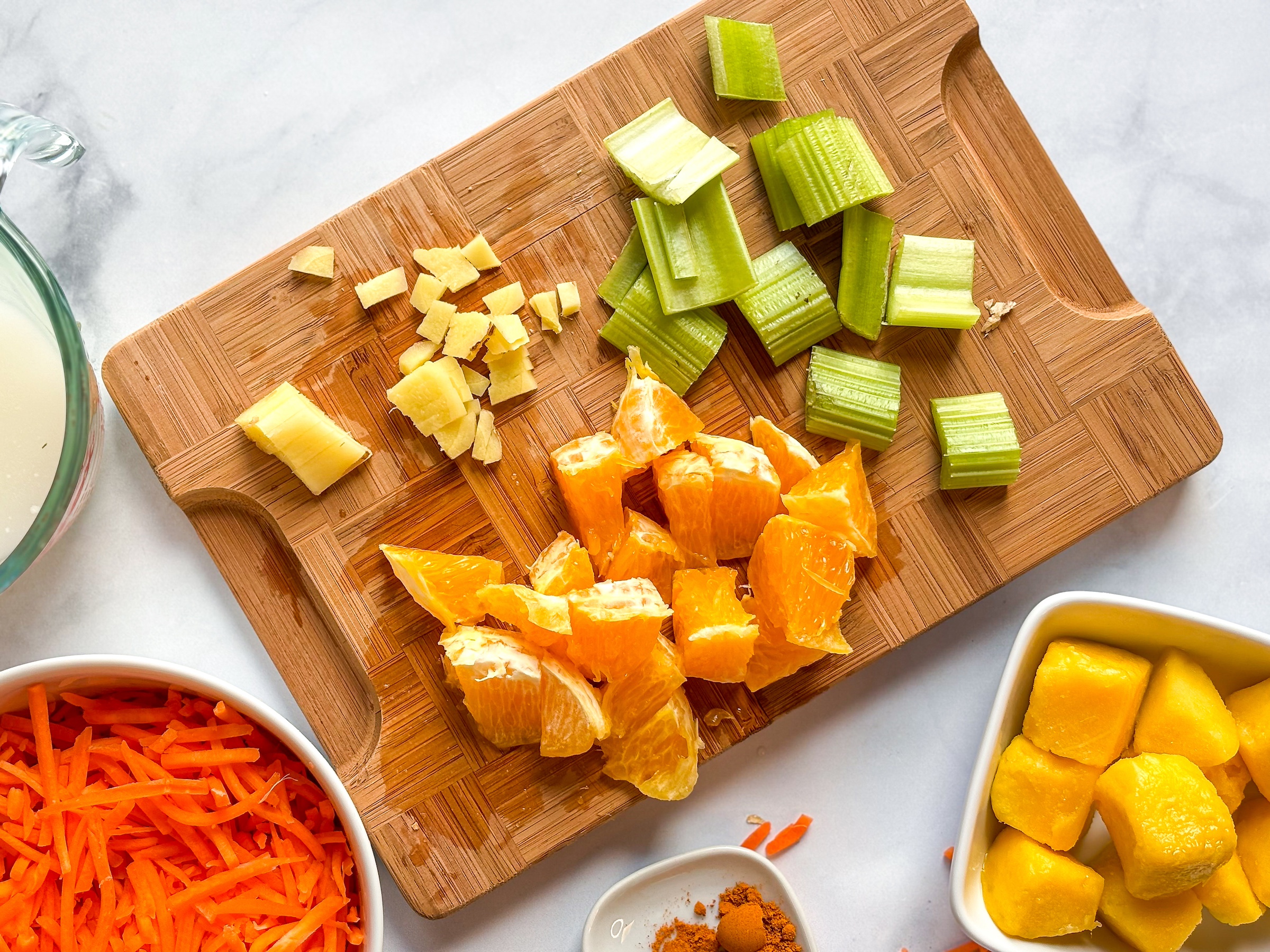 Carrot smoothie ingredients being prepped on a cutting board. 