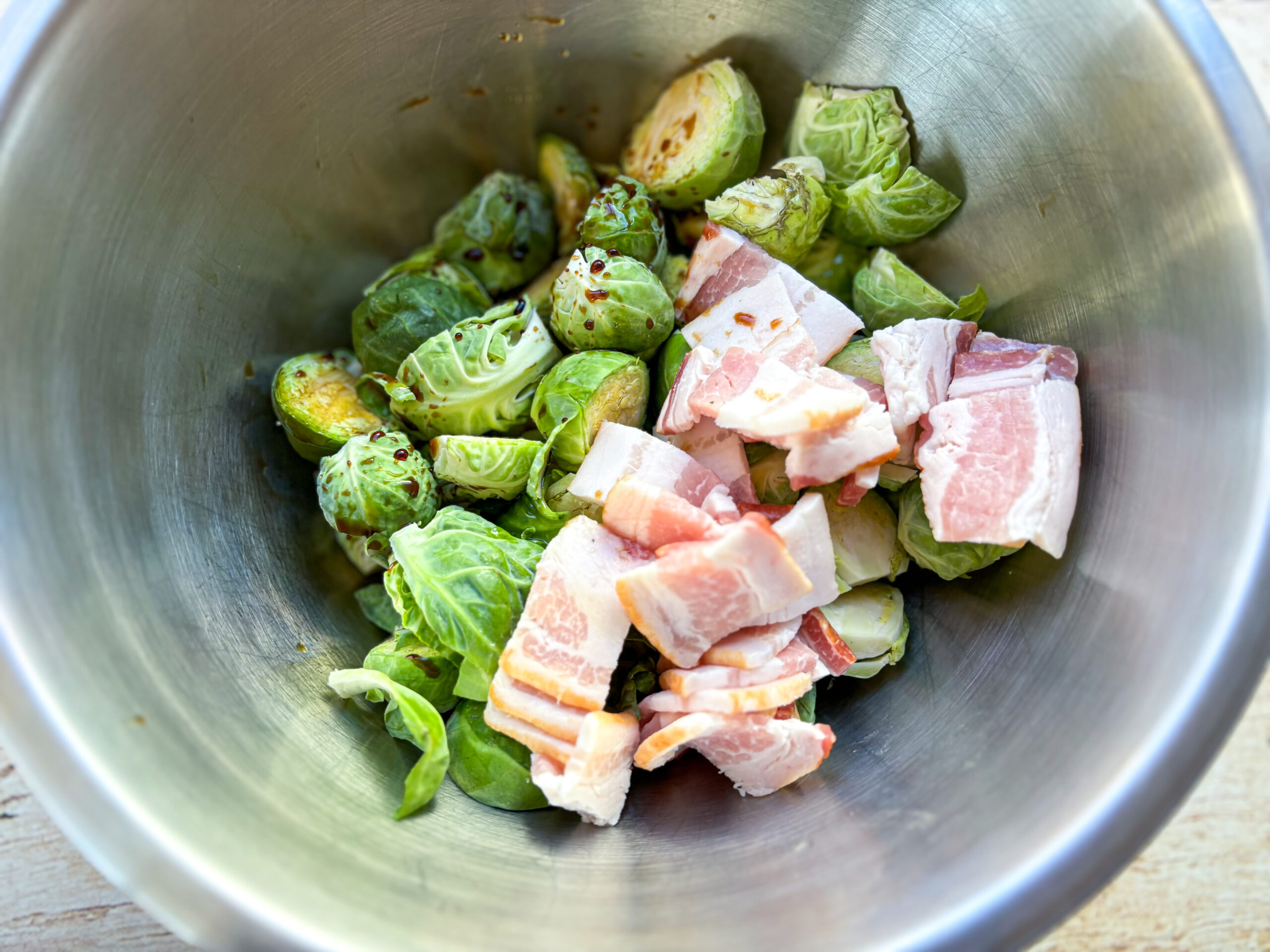 Air fryer balsamic brussels sprouts in a bowl being mixed. 