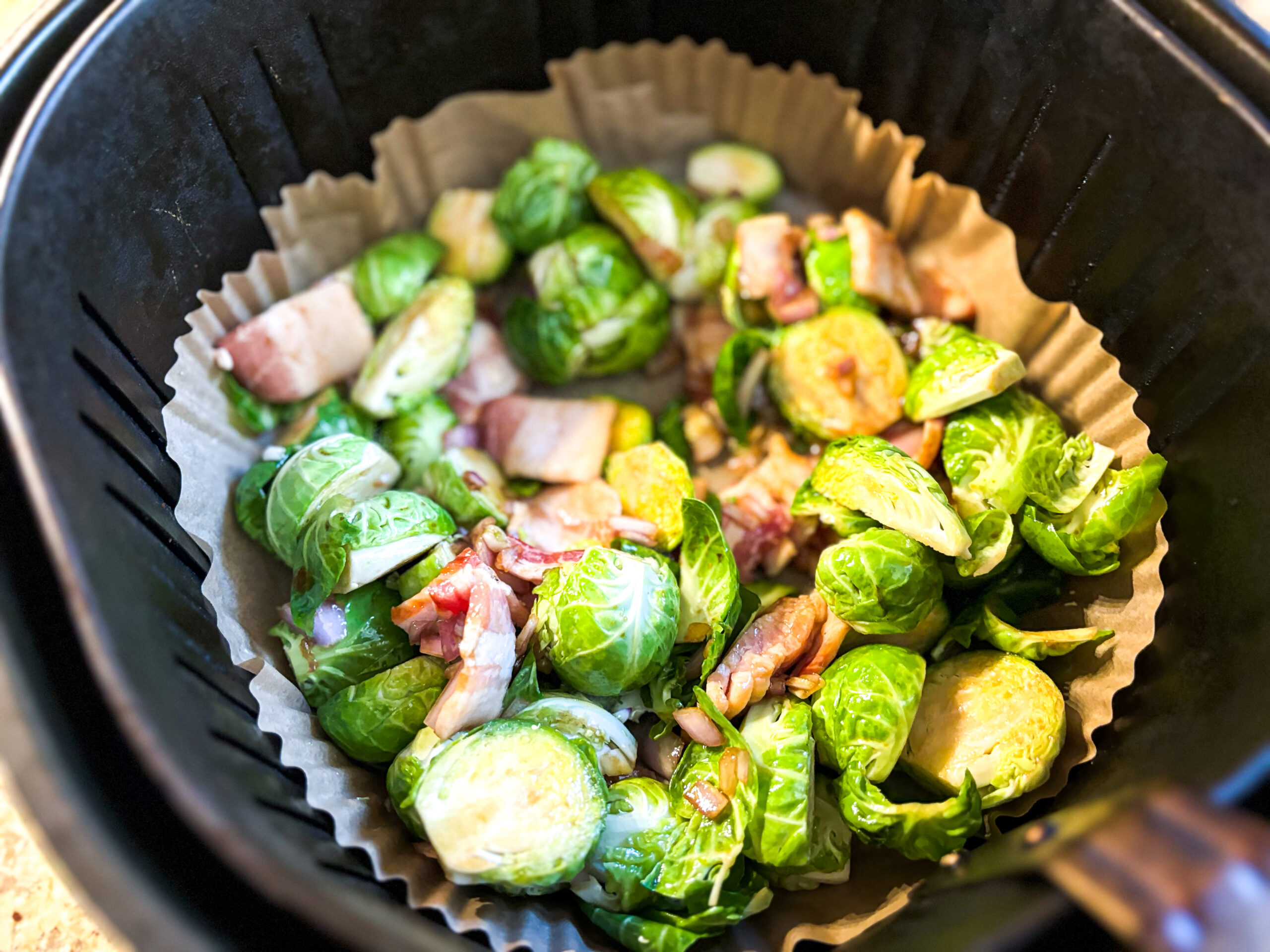 Ari fryer balsamic brussels sprouts in the air fryer basin. 