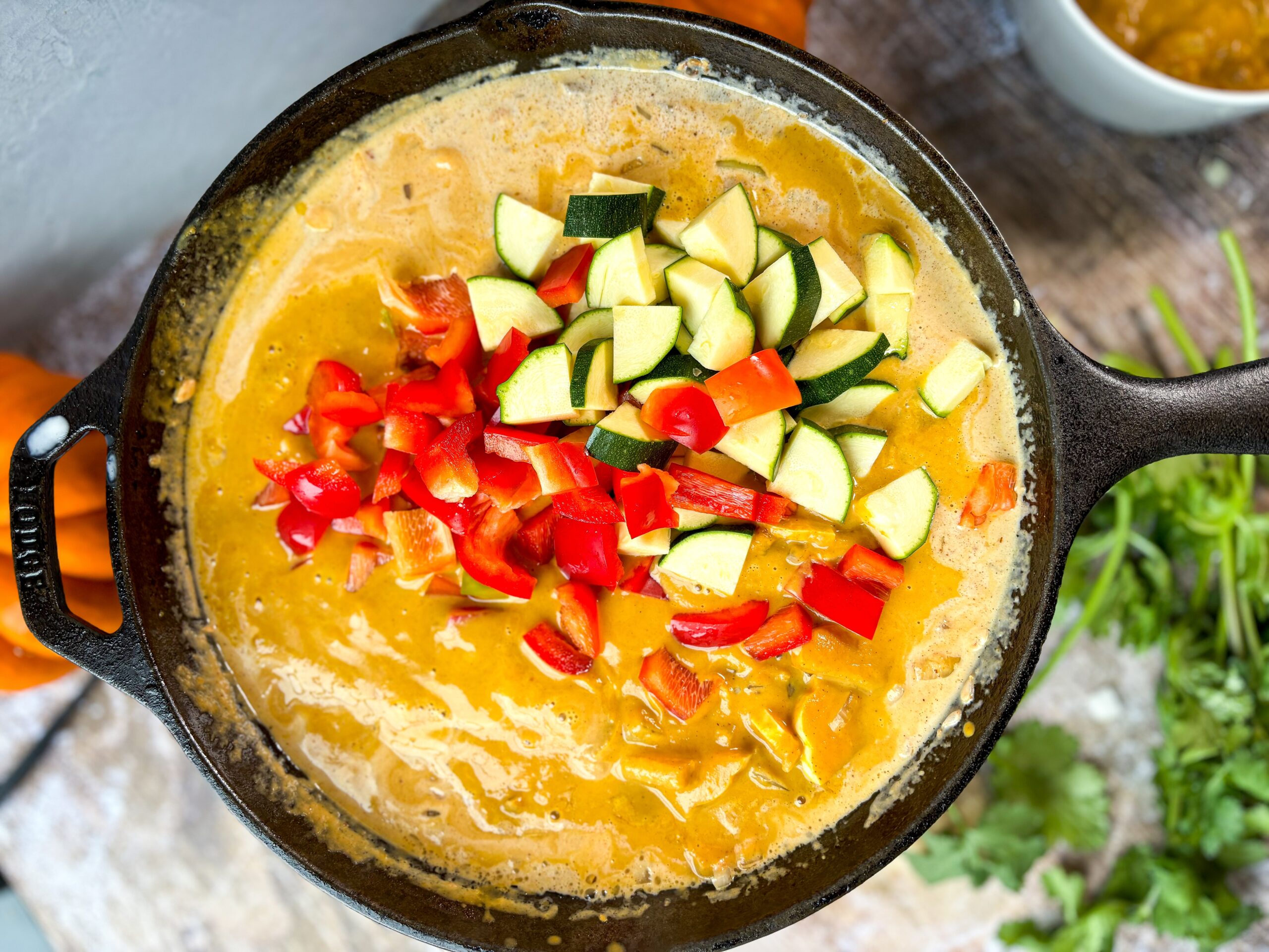 Pumpkin curry cooking in a cast iron pan. 