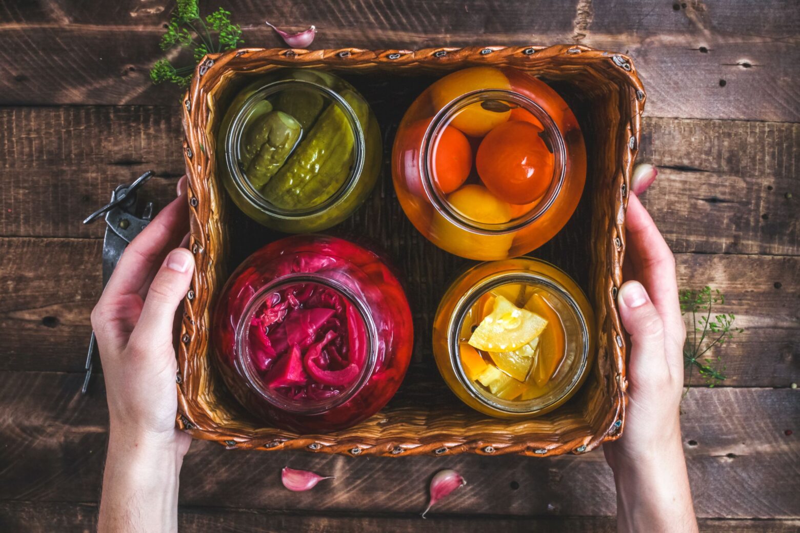 Above shot of 4 jars of pickled vegetables in a square basket