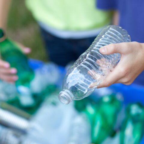 A boy and girl taking part in plastic recycling.