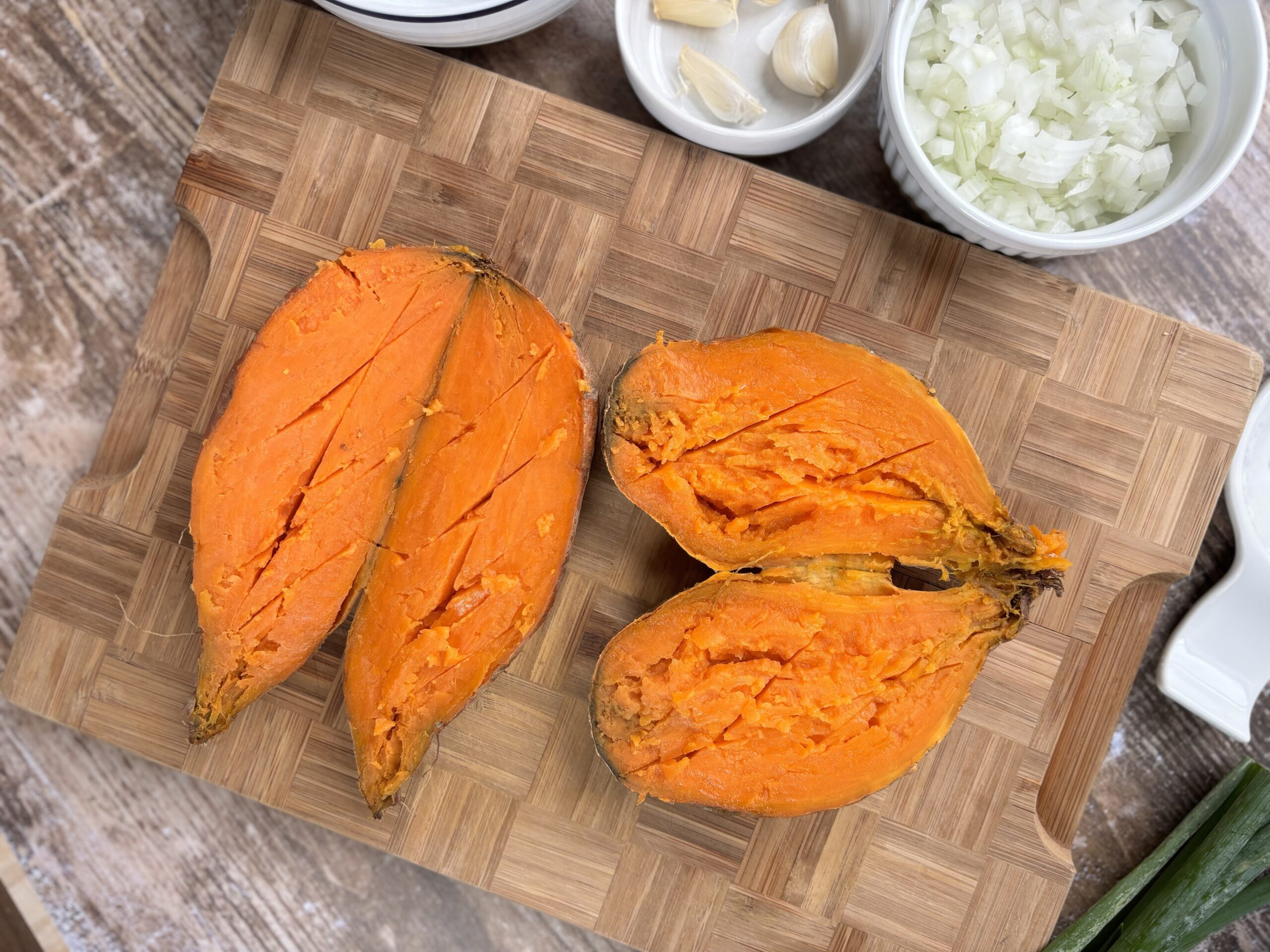 Baked sweet potatoes taken out of the oven with slits. 