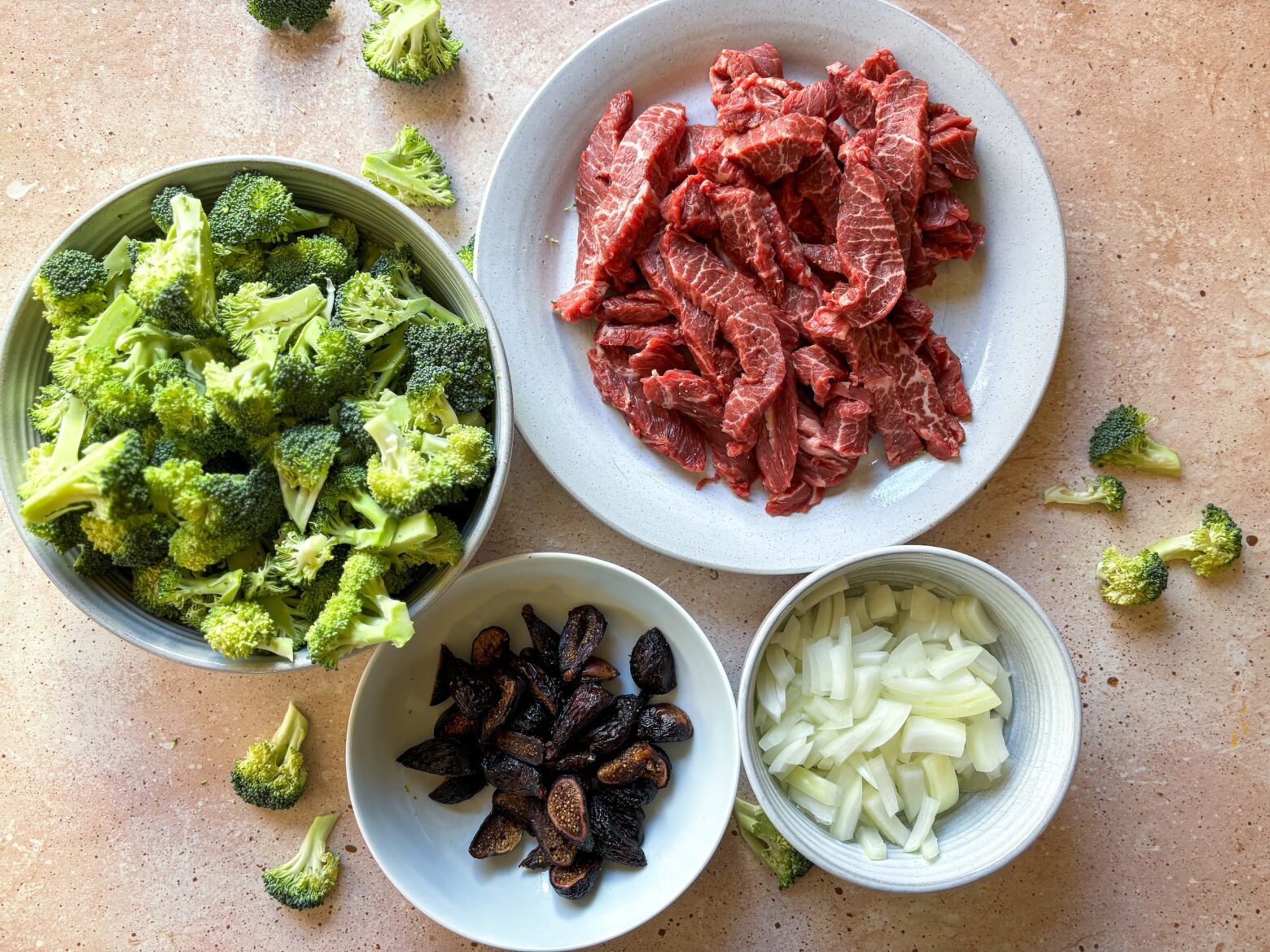 Beef and broccoli prepped ingredients in bowls.