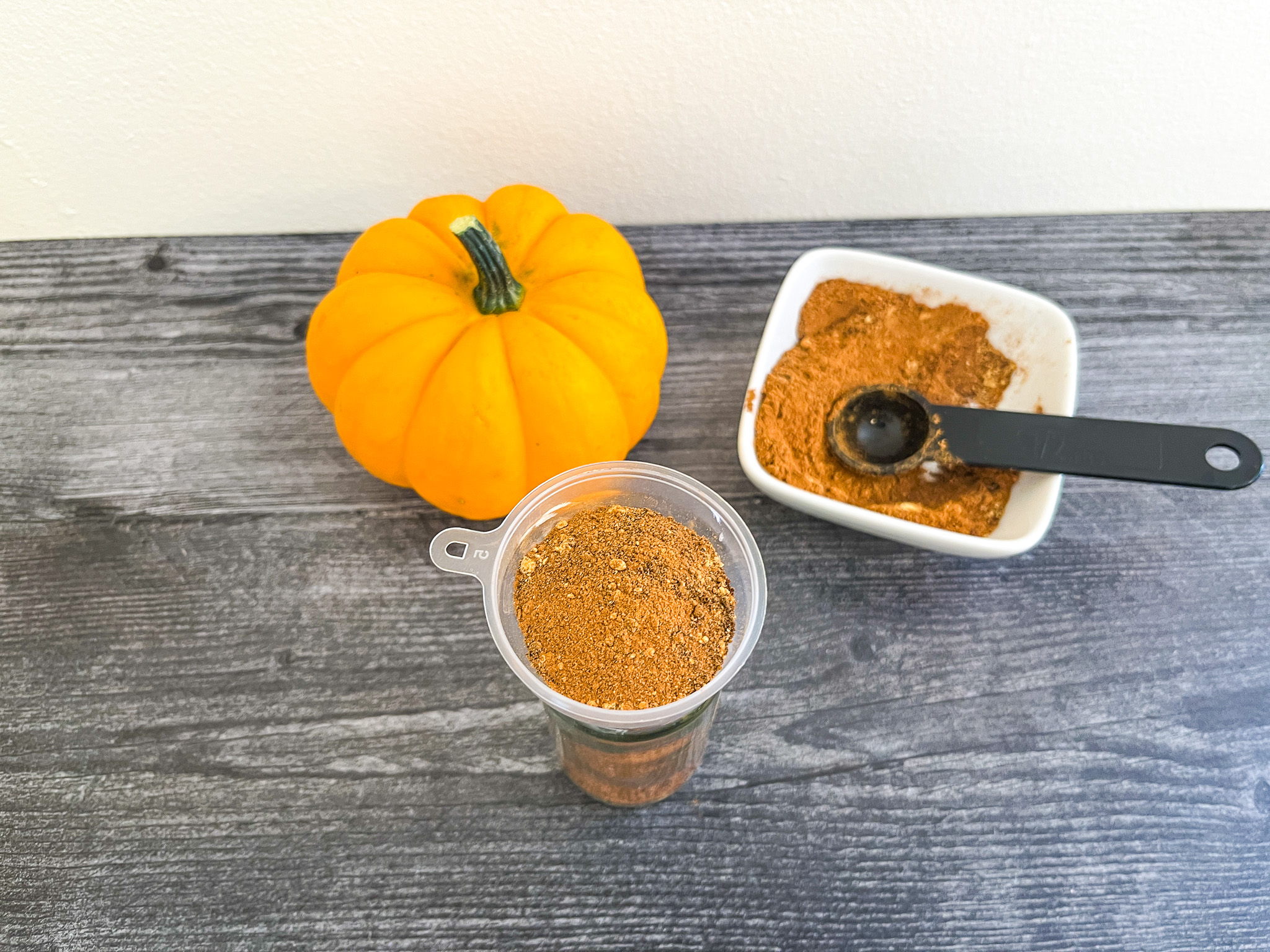 Pumpkin pie spice being put into a jar.