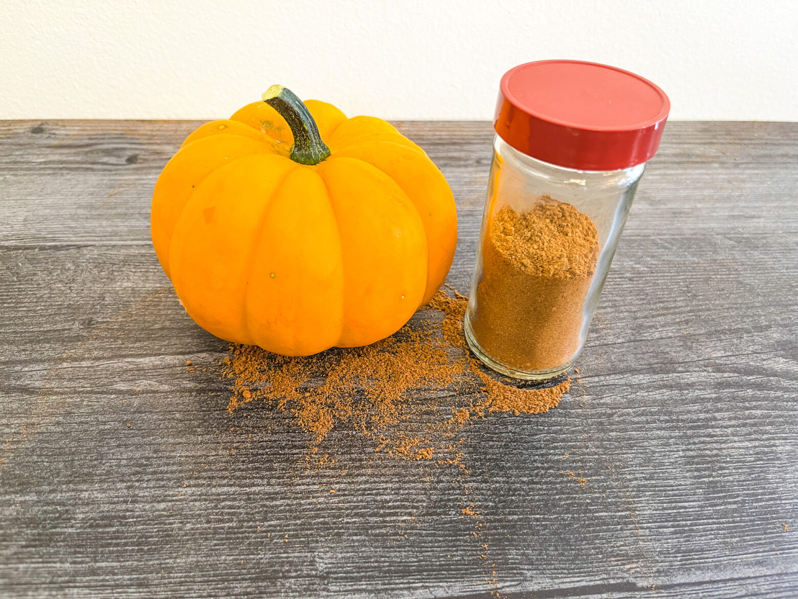 Pumpkin pie spice in a jar with a pumpkin.