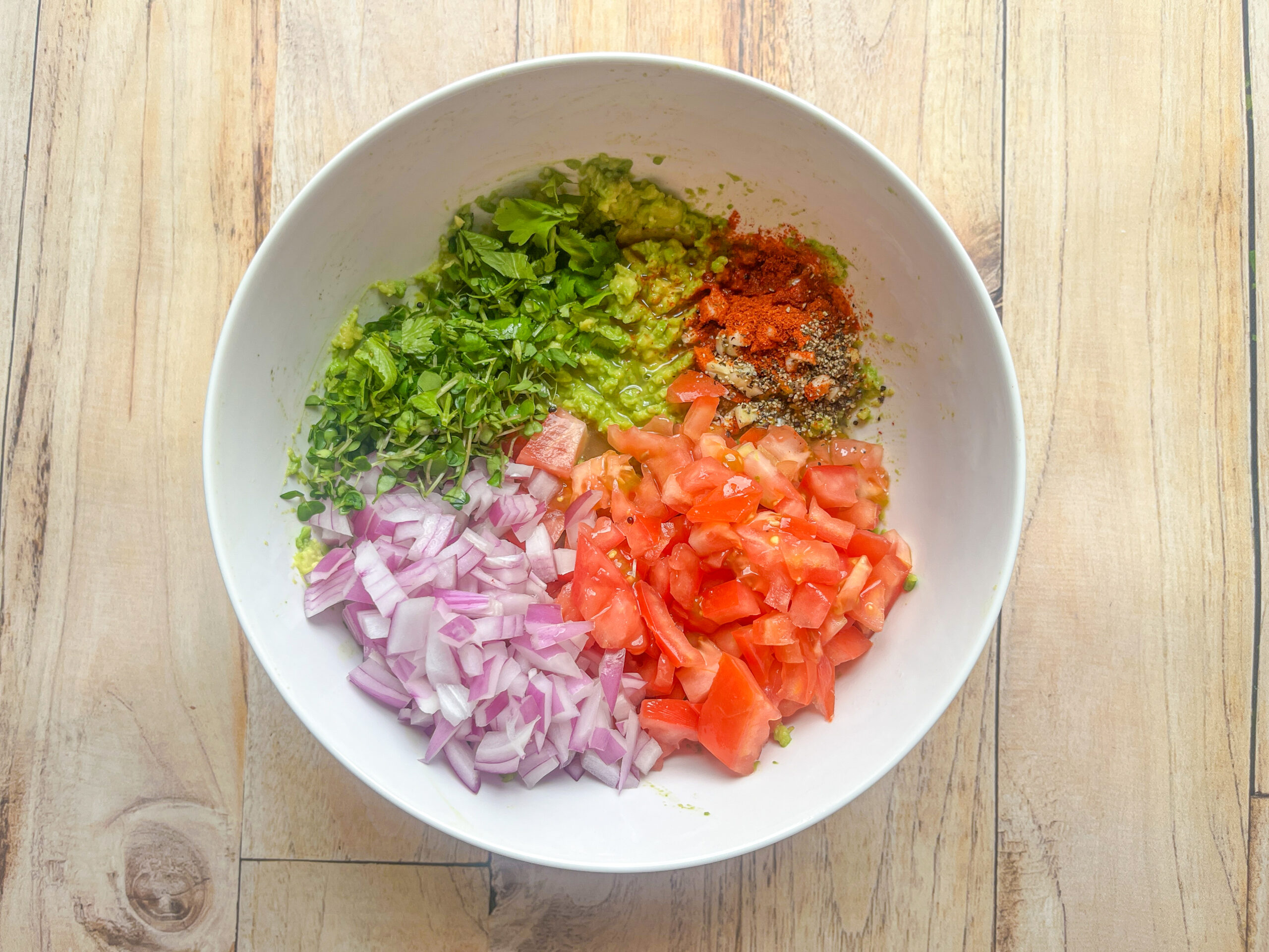 Microgreens guacamole prepped ingredients in a bowl. 