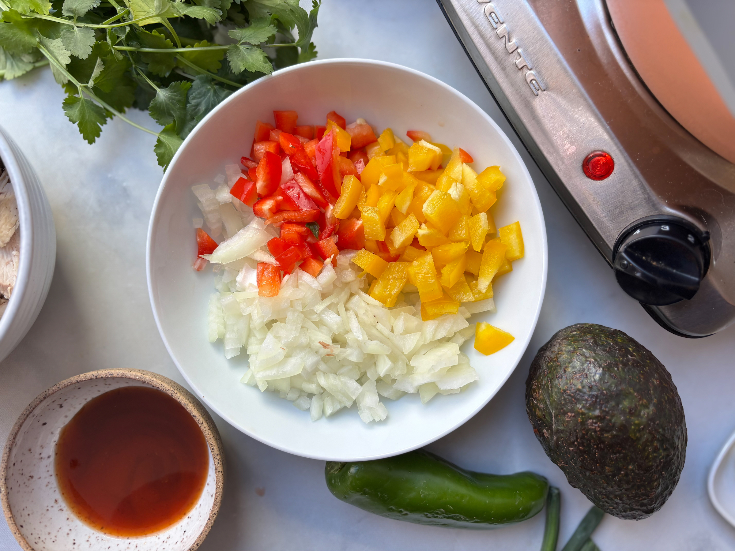 Chopped ingredients prepared in a bowl for the 5-layer dip. 