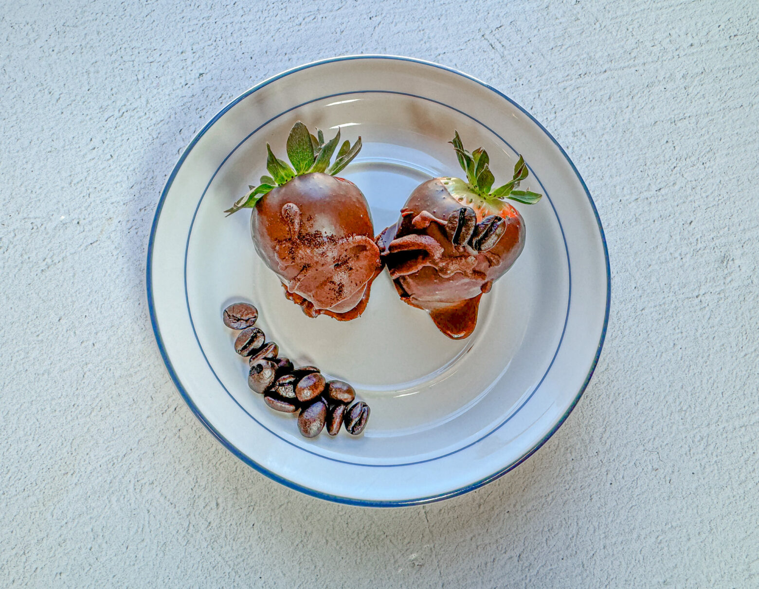 Espresso chocolate-covered strawberries finished on a plate.