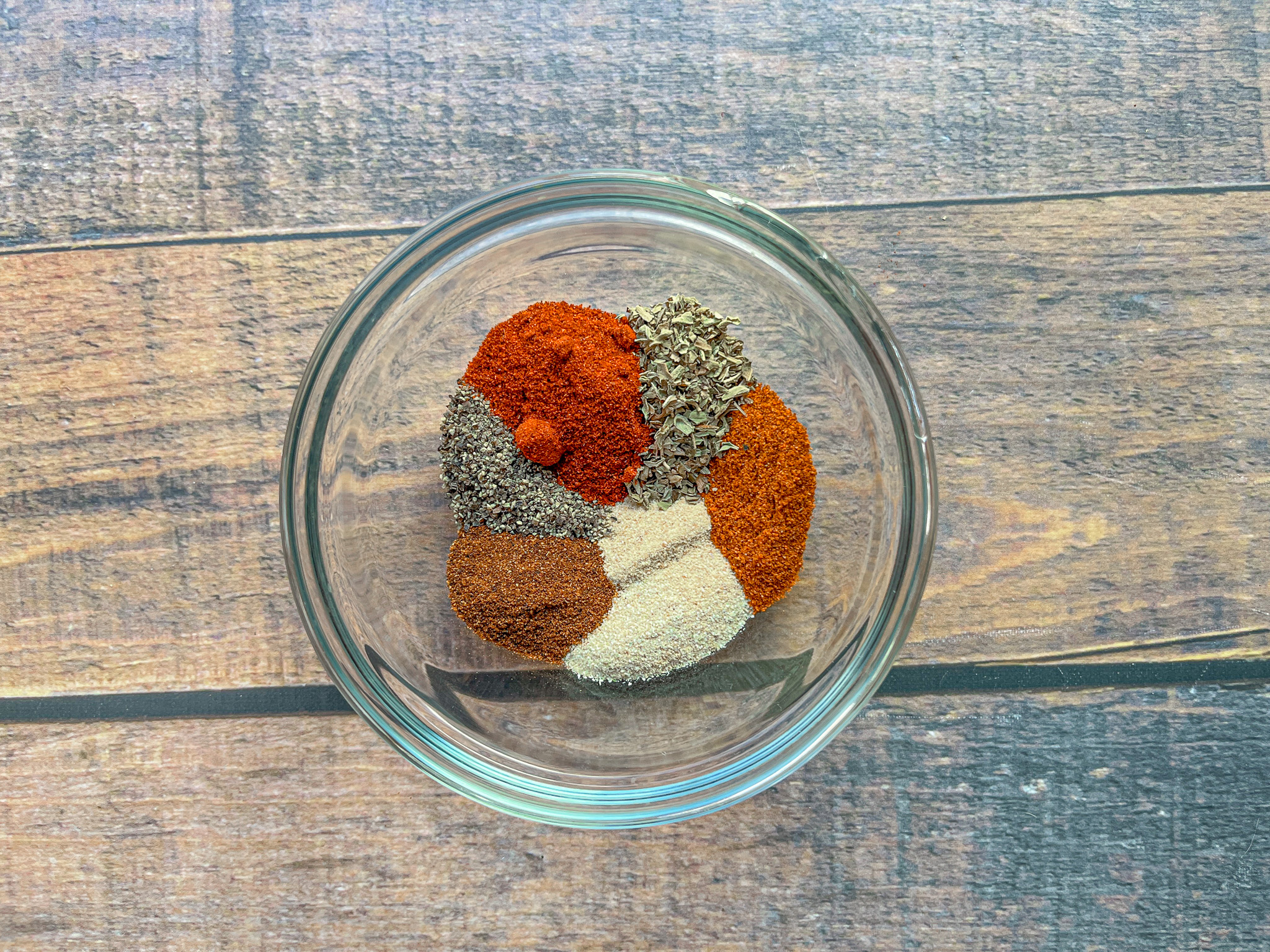 Cajun seasoning pre-mixed in a glass bowl. 