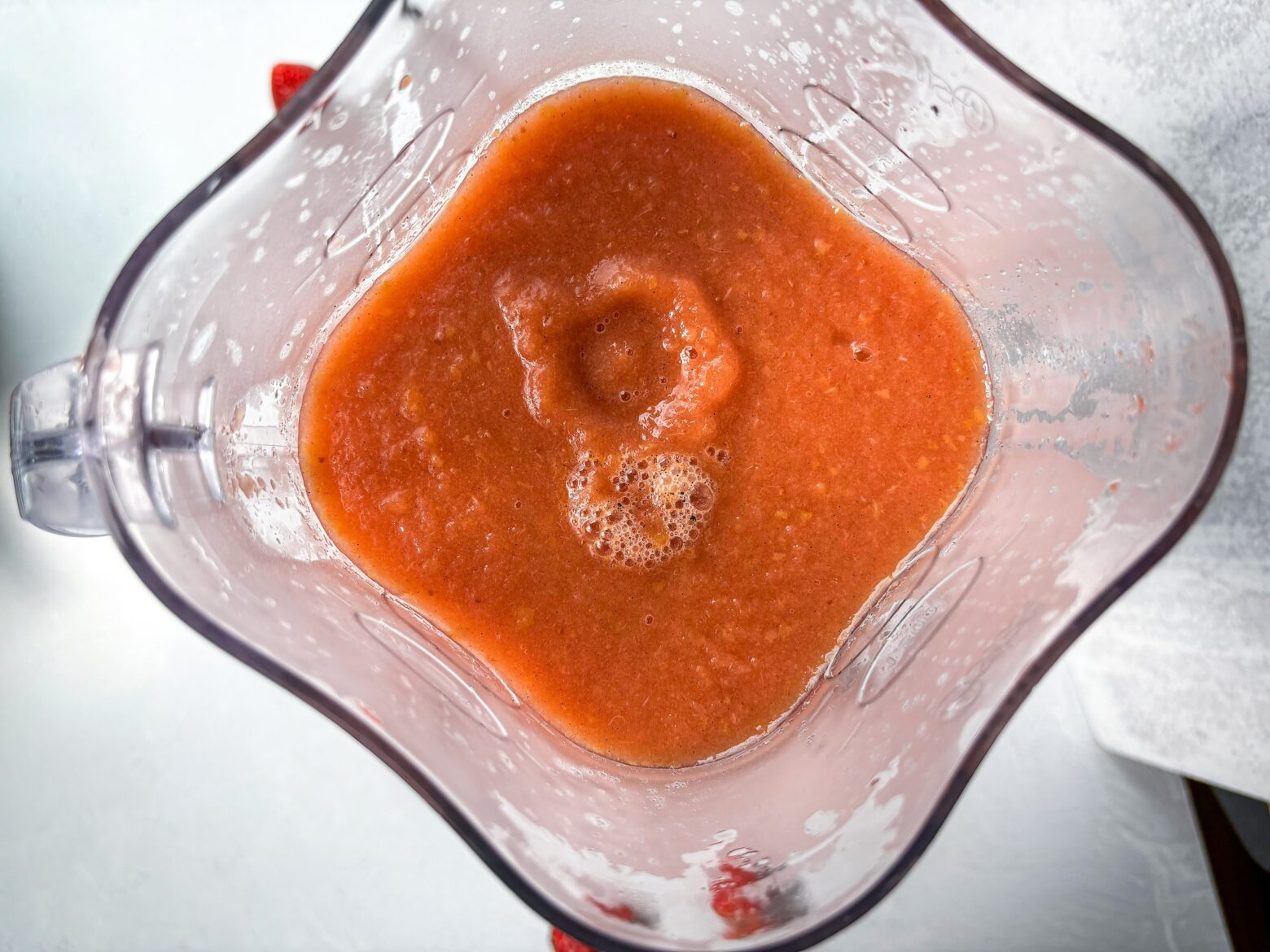 Blending the strawberry applesauce in a blender.