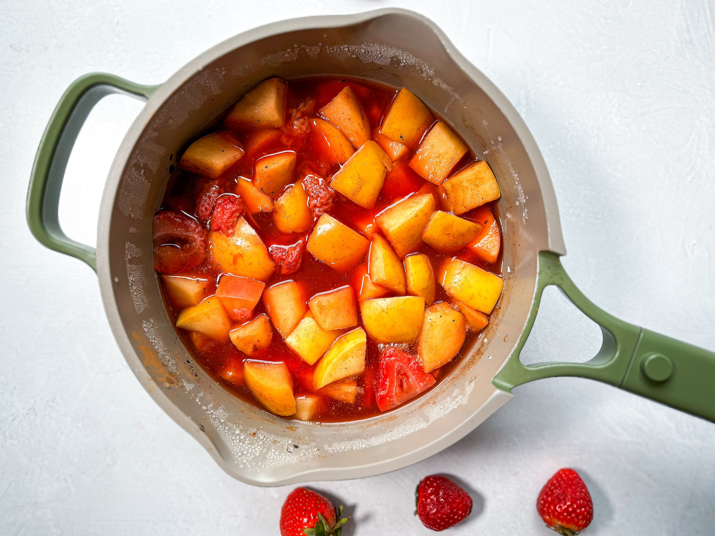 Strawberry applesauce being made over the stove. 