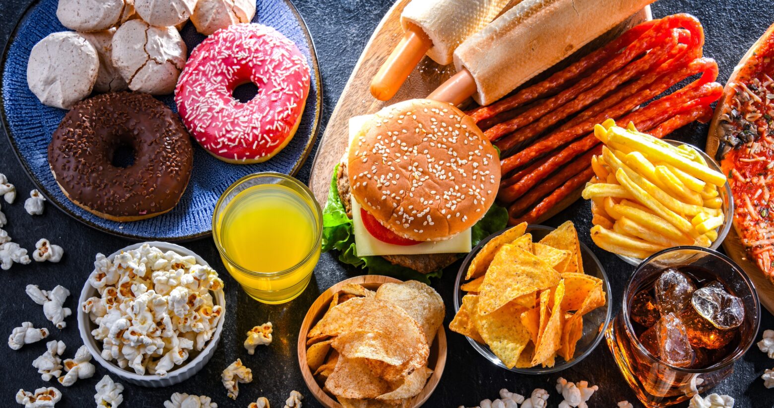 Junk food and ultra processed foods spread out on top of a table.