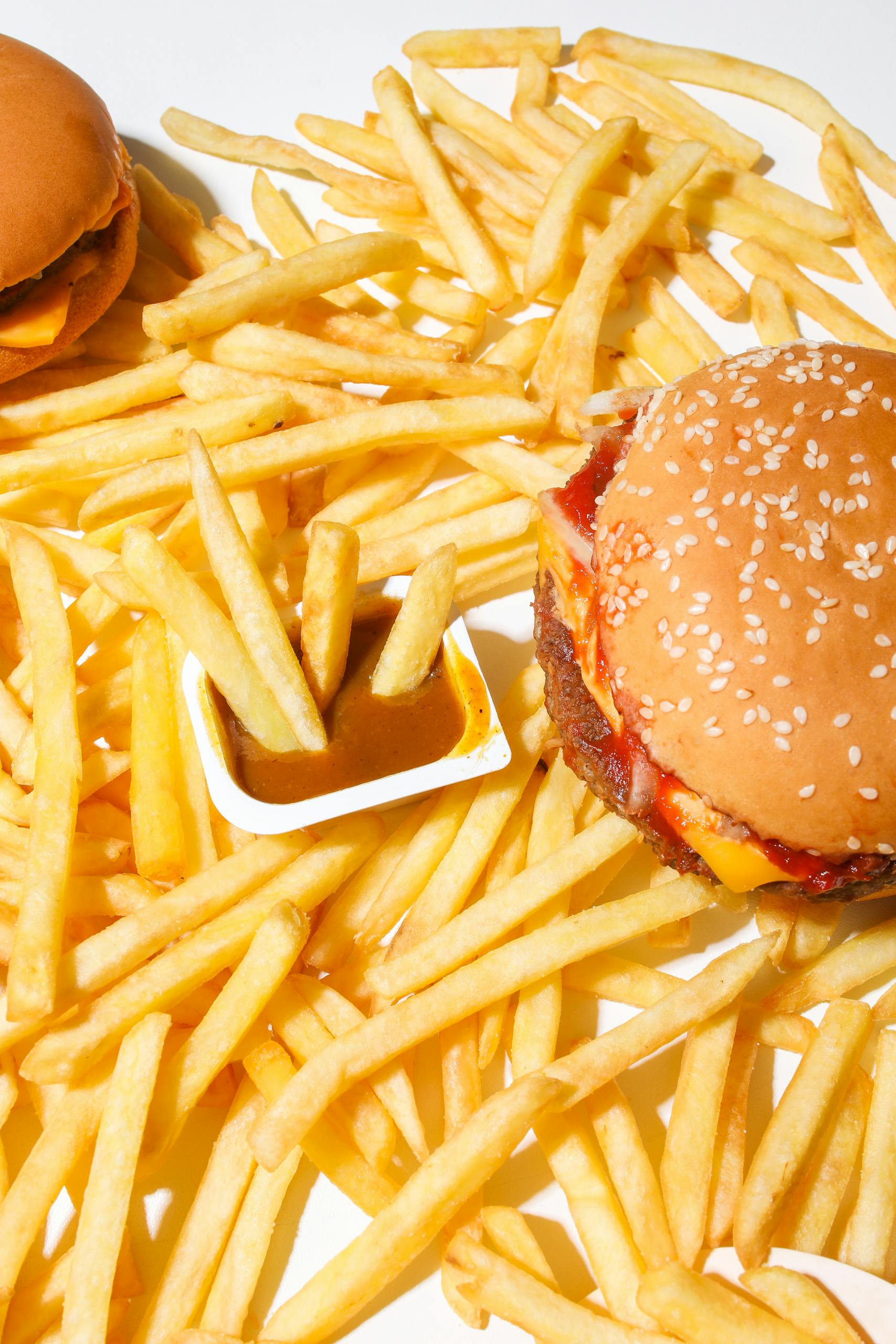 A delicious burger and fries on a white background, ideal for fast food themes.