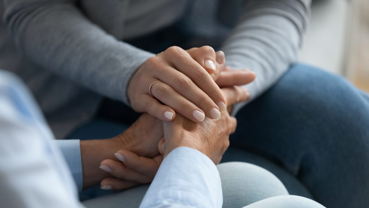 Women holding hands talking about a diagnosis.