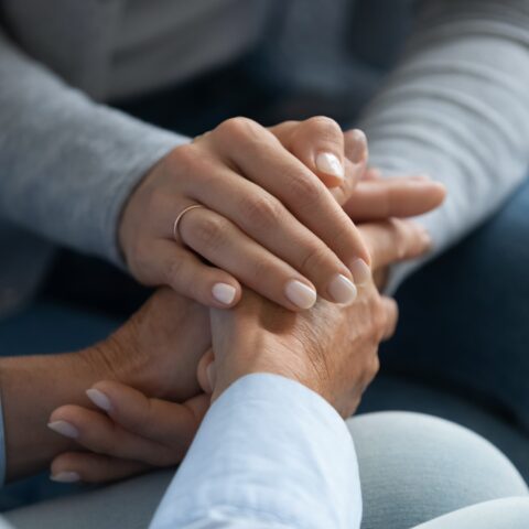 Women holding hands talking about a diagnosis.