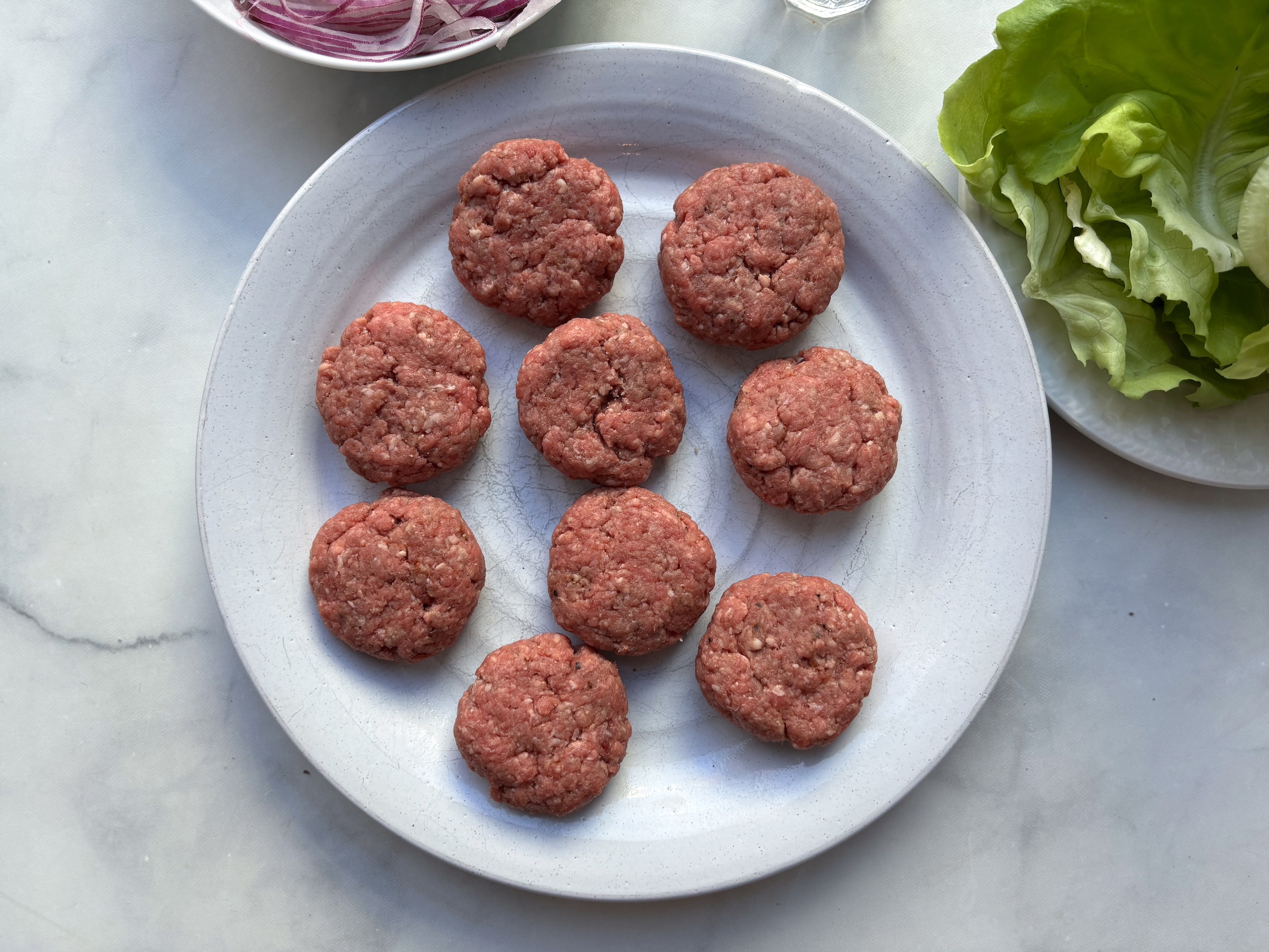 Prepping the ground beef of the bunless sliders on a plate. 