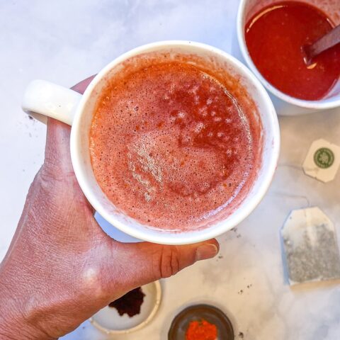 Elderberry citrus elixir being held in a mug.