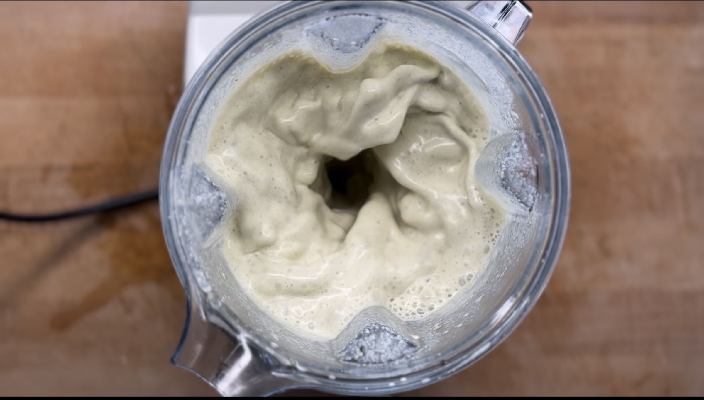 Pistachio milk being blended with the blender lid off. 