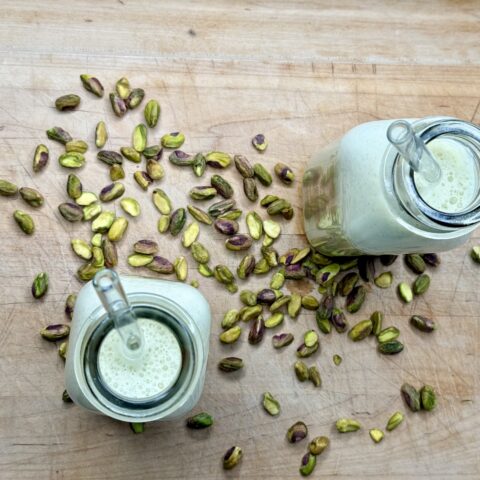 Overhead shot of pistachio milk on a cutting board.