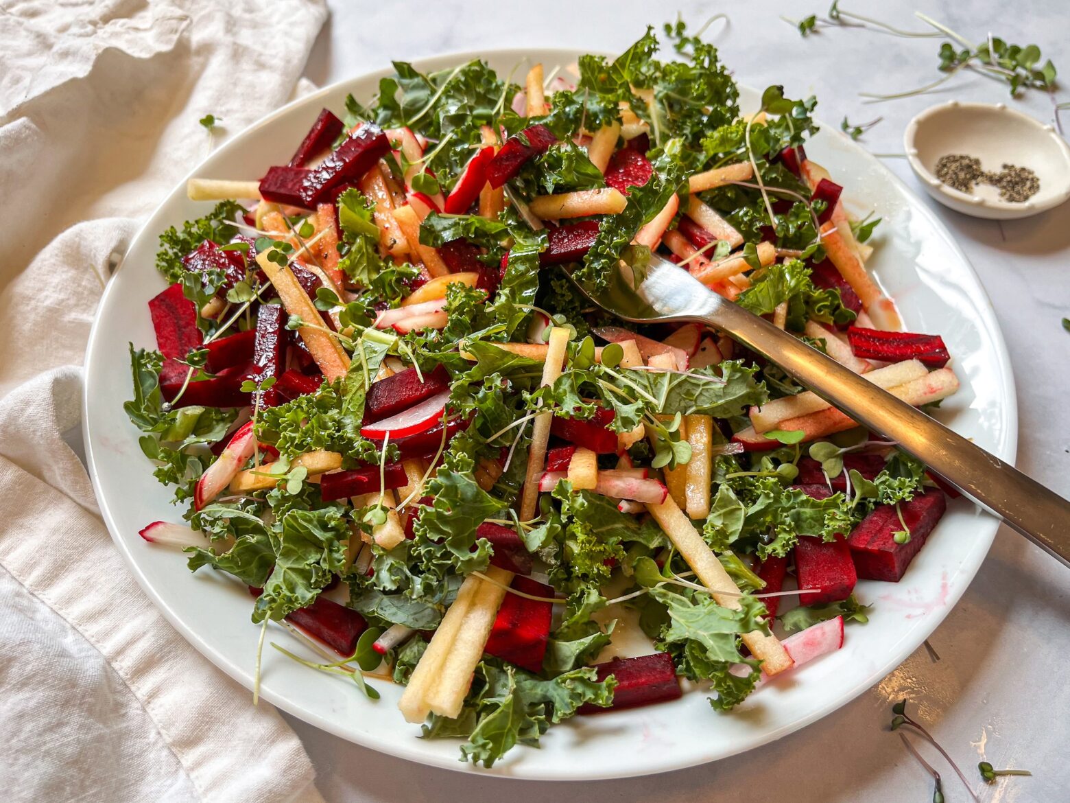 Close-up shot of red root kale salad plated with a fork.