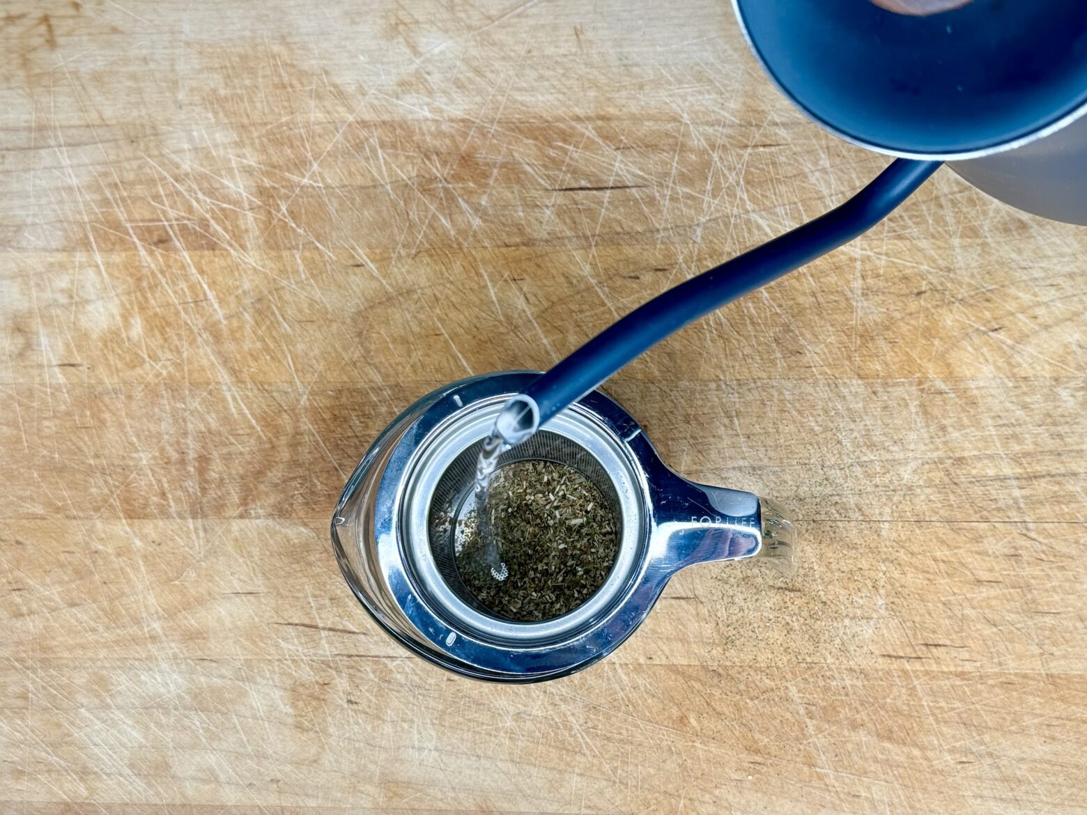 Tart cherry juice mocktail being prepped with warm water and loose leaf tea.