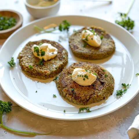 Vegan crab cakes finished and topped with mayo.