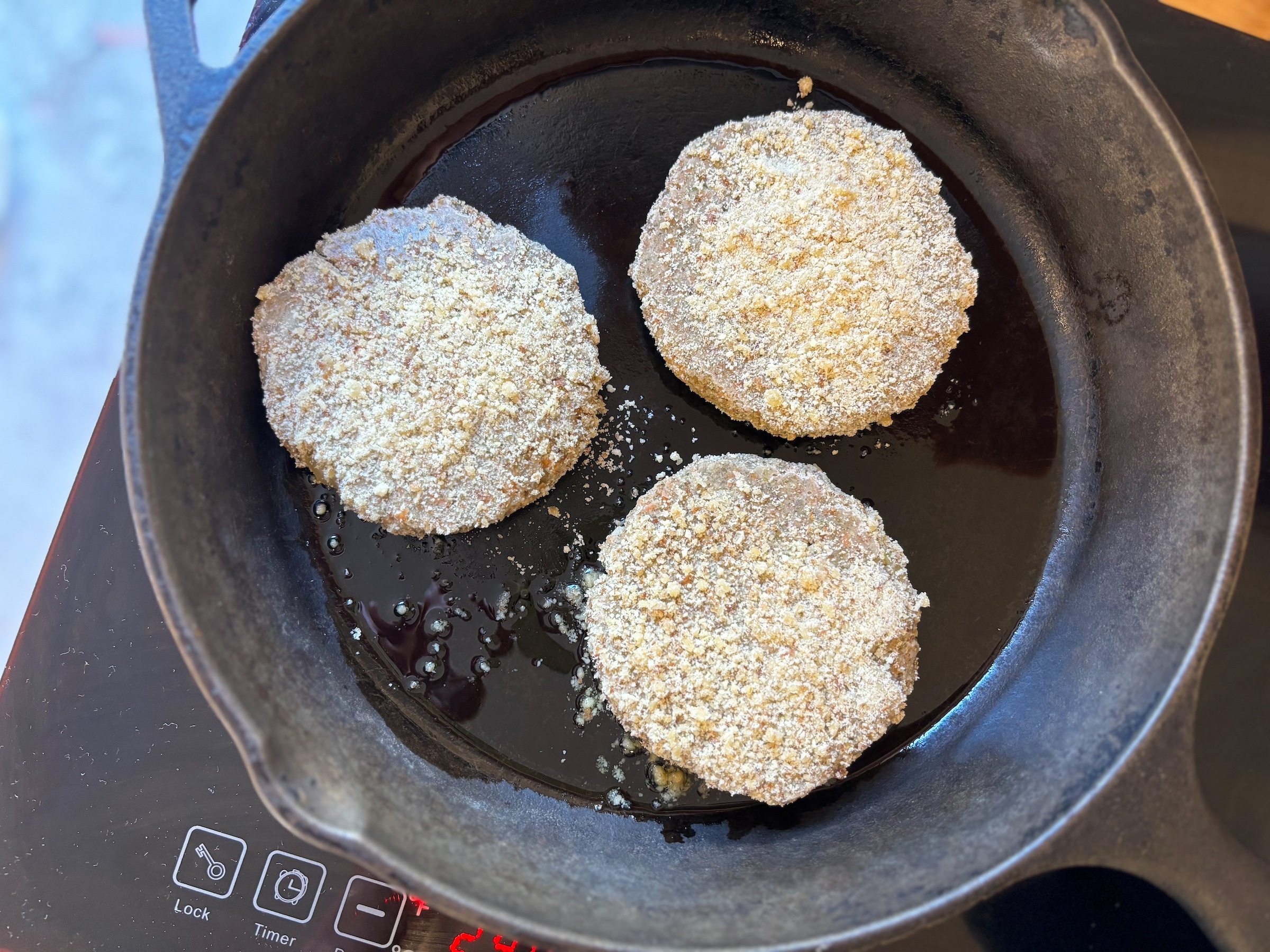 Vegan crab cakes being cooked on a pan. 