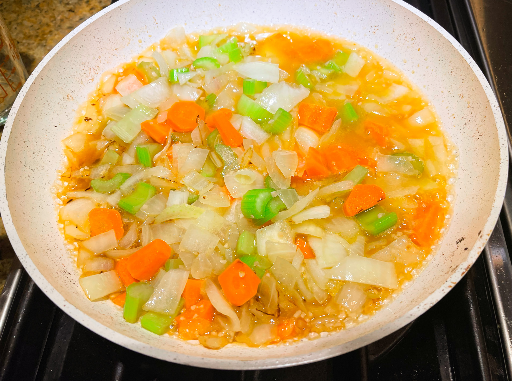 Vegetables for Lobster Bisque cooking over the stove.