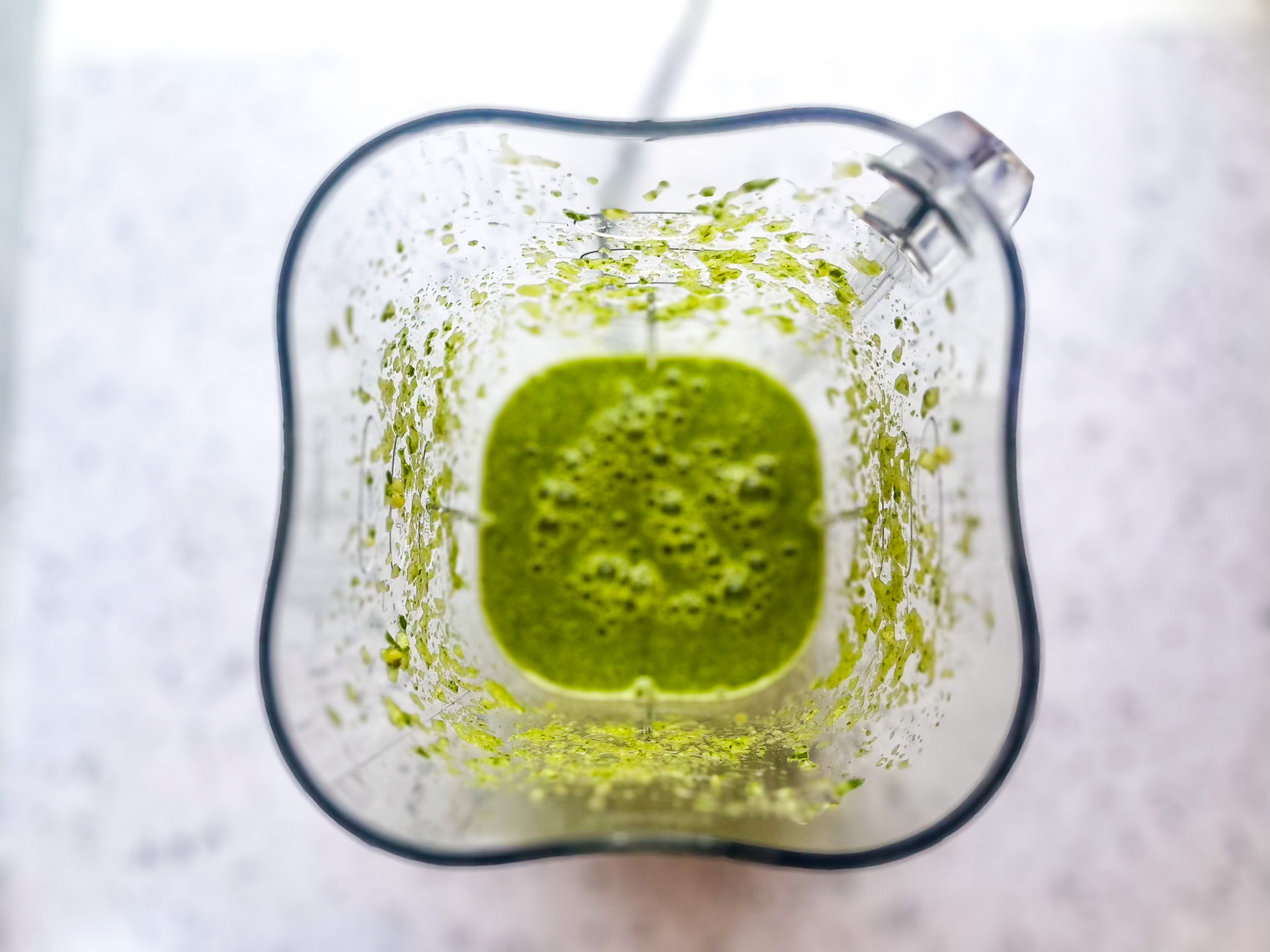 Tropical green juice with an above view from a blender. 