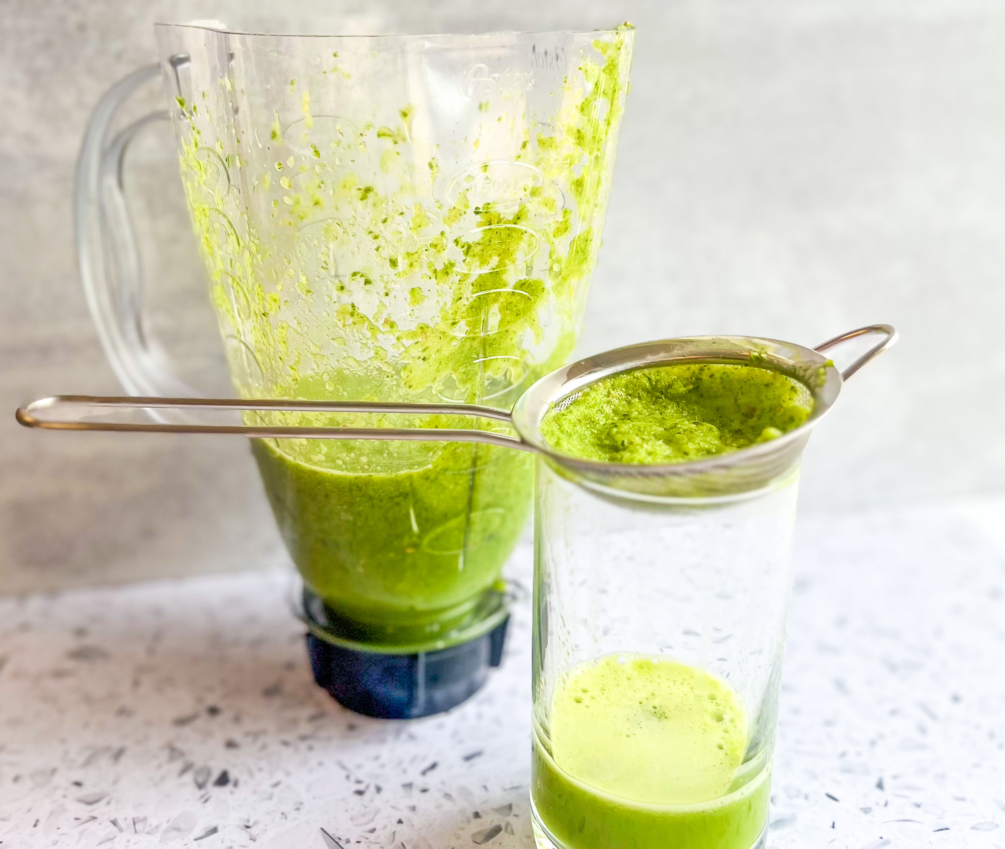 Tropical green juice prep step with straining the juice. 