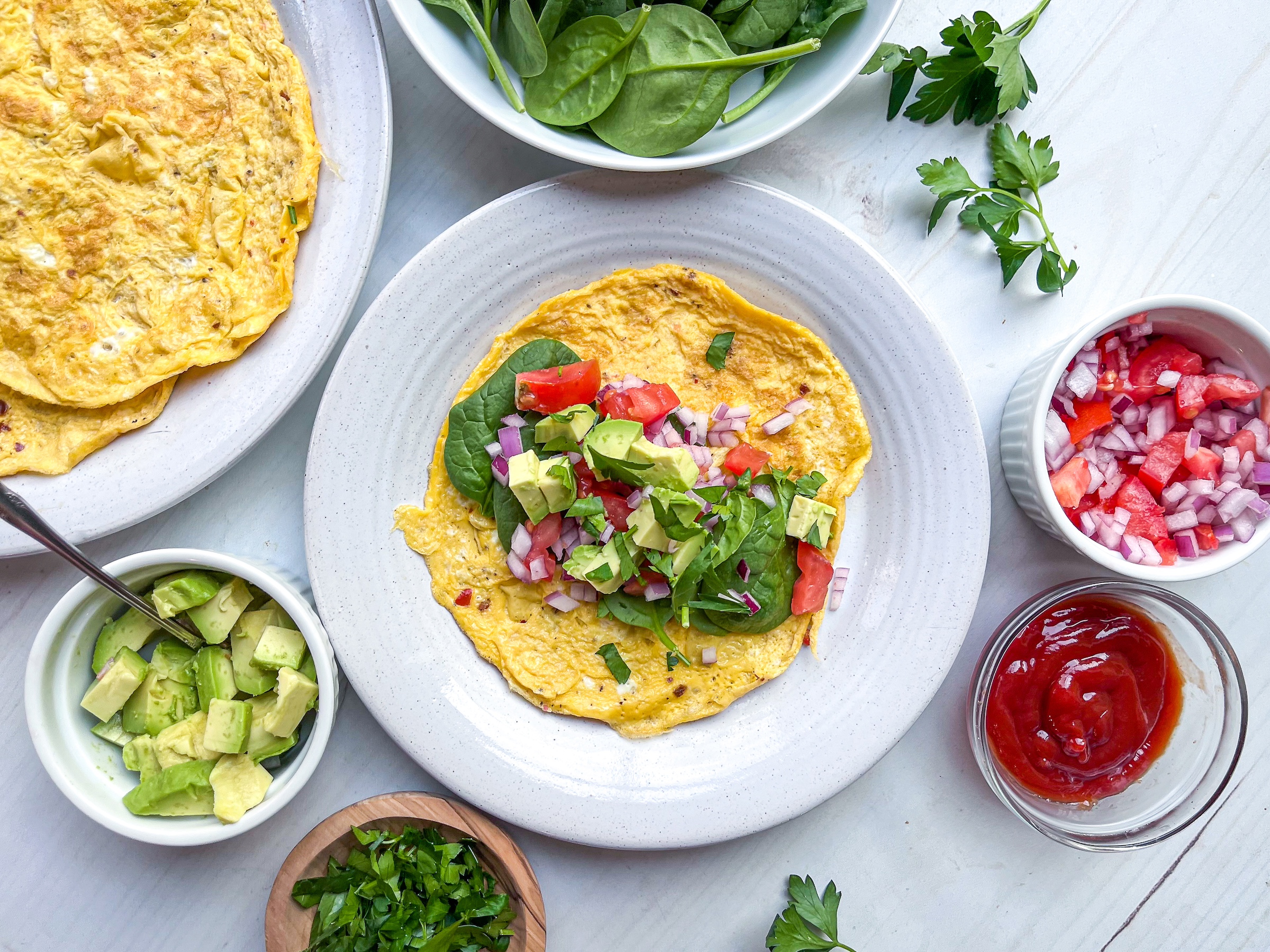 Veggie breakfast burritos being filled on a plate. 