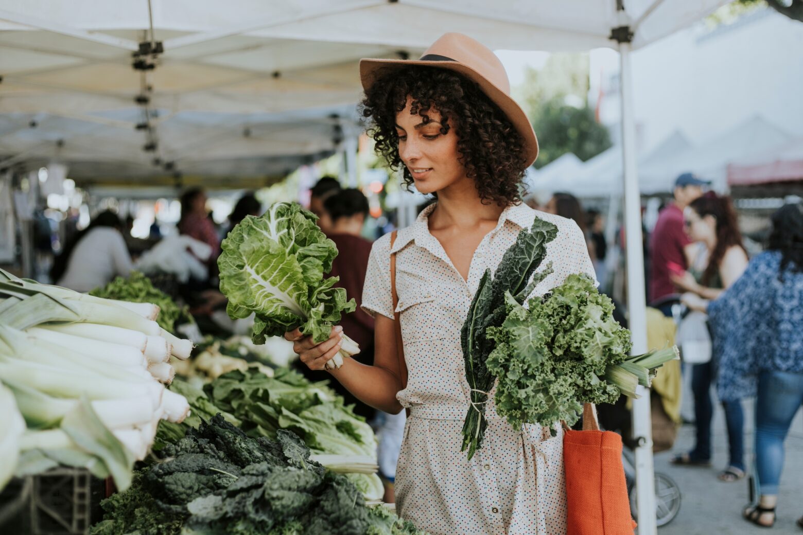 Women shopping at the farmer's market for kale.