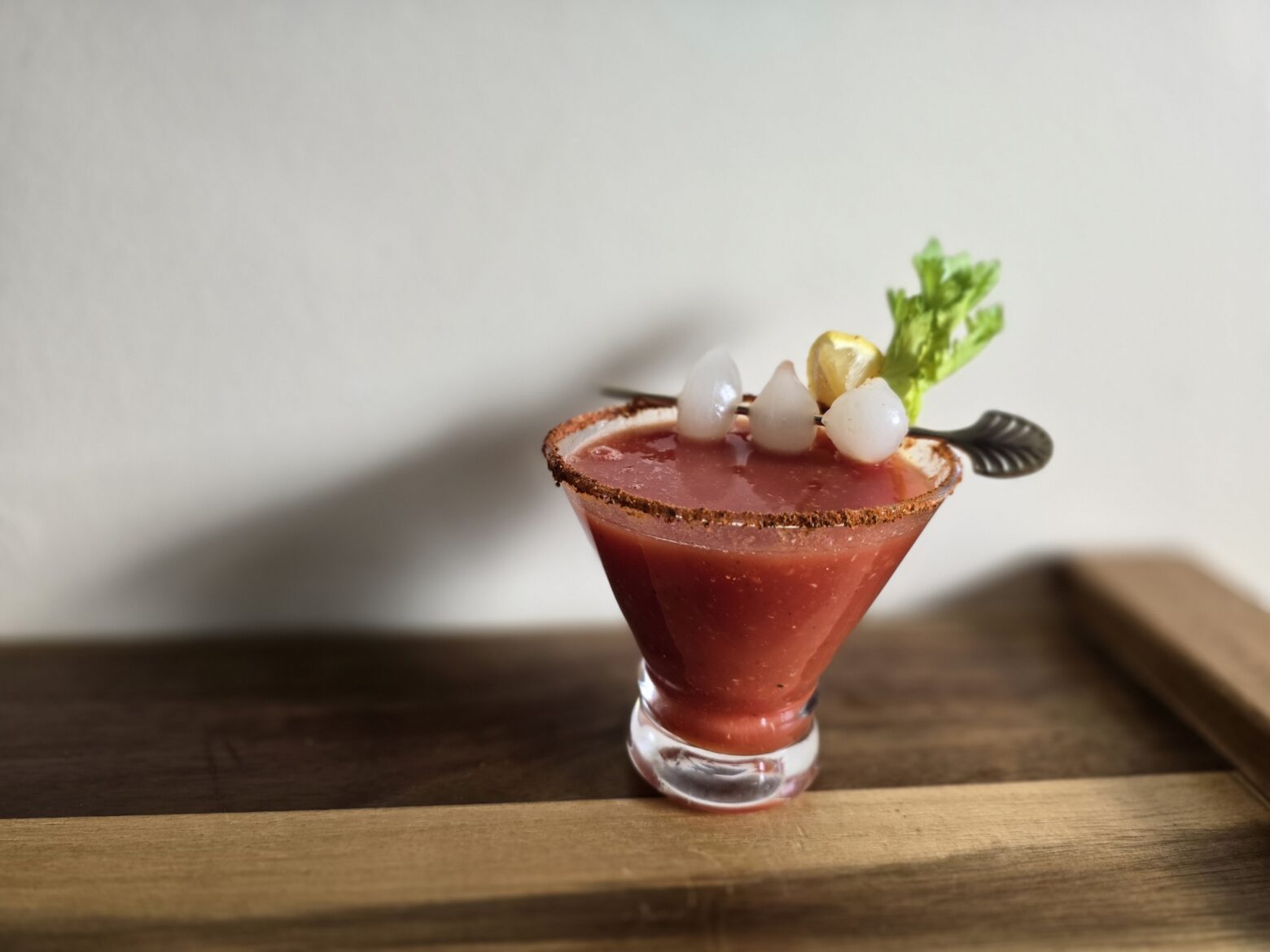 Bloody mary mocktail finished, on a wooden table.