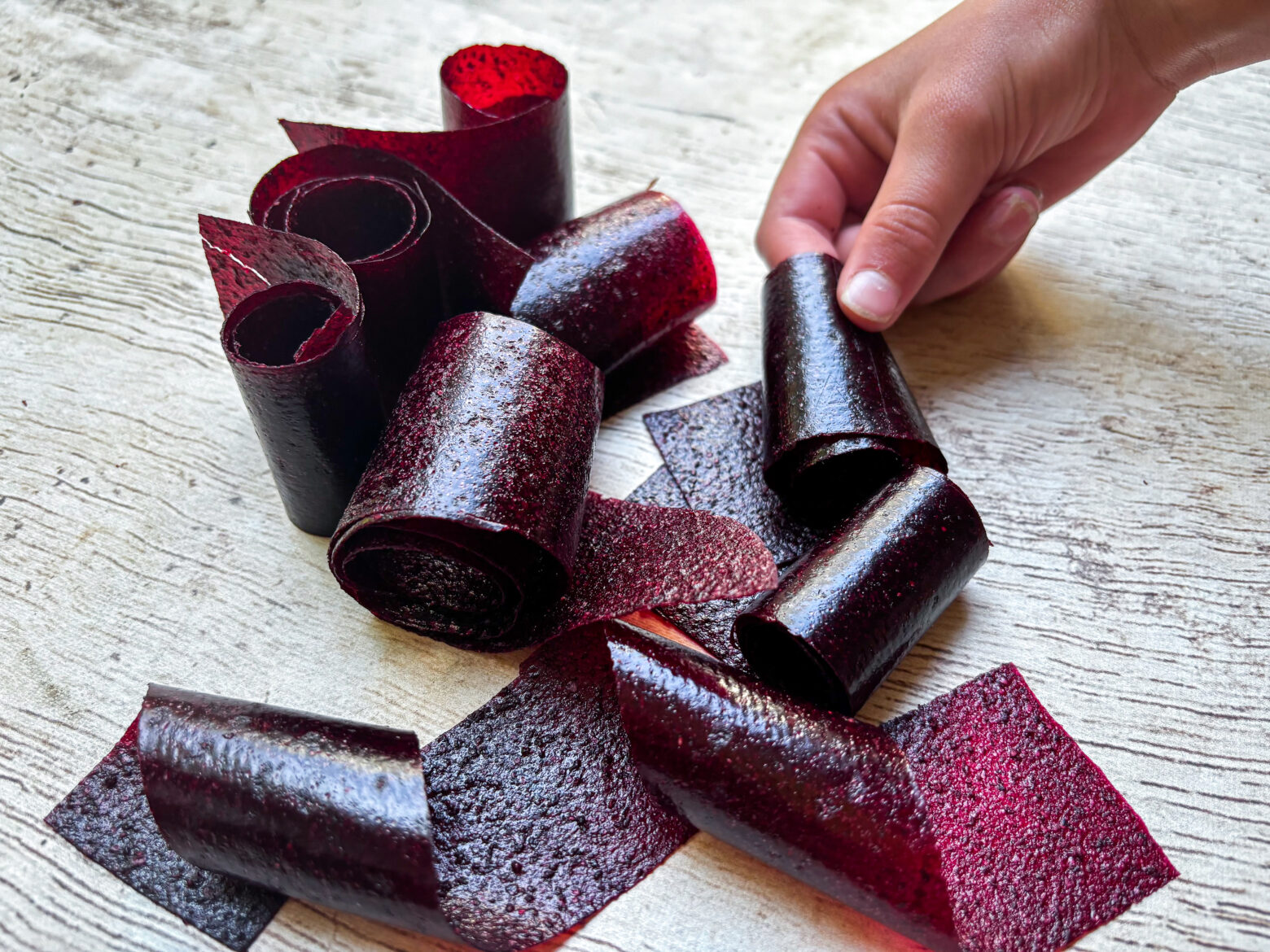 Grabbing fruit roll ups laid out on table