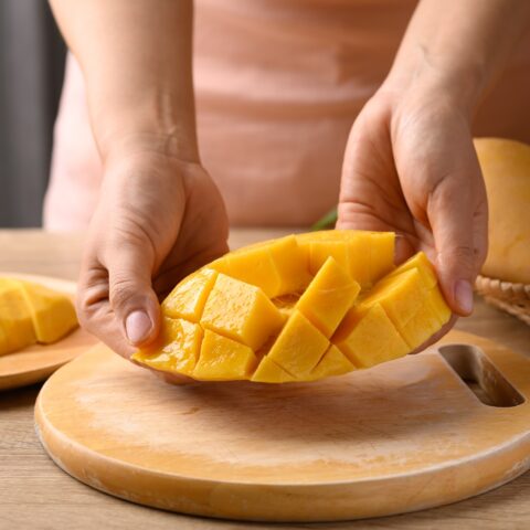 A mango sliced in half and cubed.